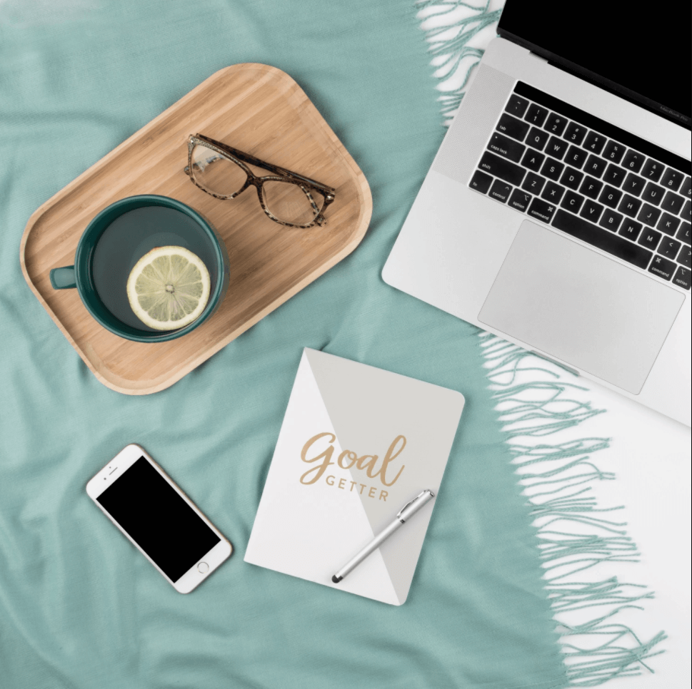 Flat lay of a laptop, smartphone, glasses, and a notebook with 'Goal Getter' text, symbolizing goal setting and productivity for mompreneurs. Flat lay of a laptop, smartphone, glasses, and a notebook with 'Goal Getter' text, symbolizing goal setting and productivity for mompreneurs.