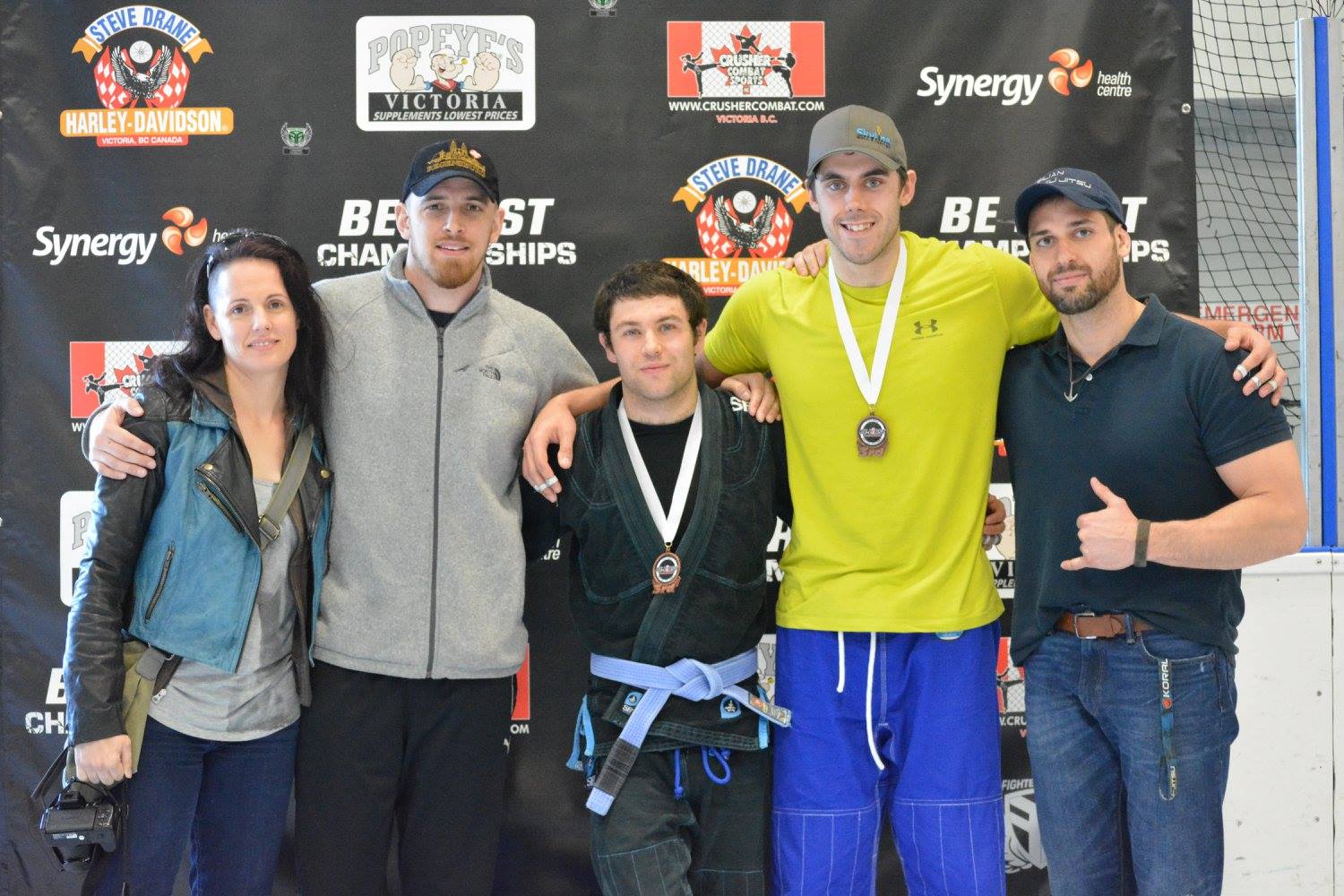 a group standing huddled at a BJJ tournament a group standing huddled at a BJJ tournament