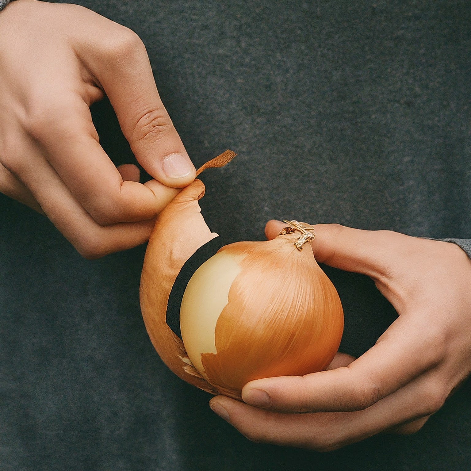 A hand peeling a onion A hand peeling a onion