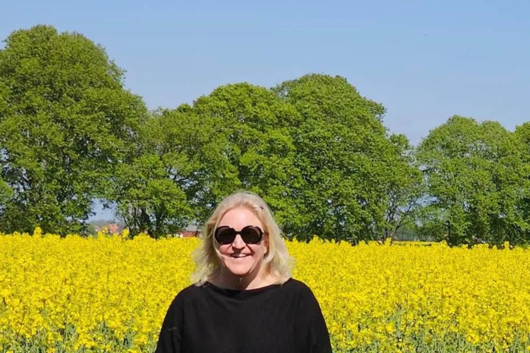 Johanna framför ett hav av gula blommor