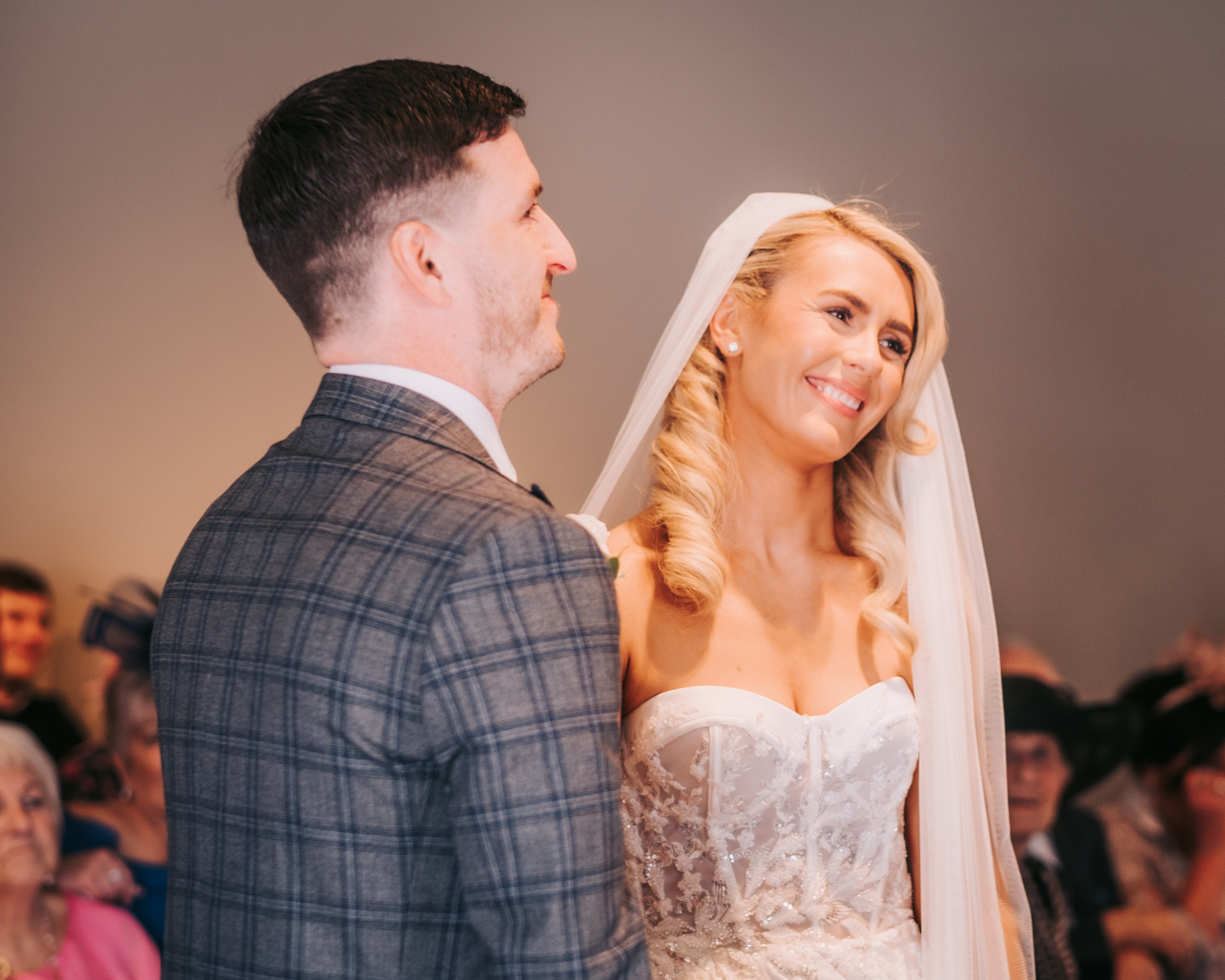 Bride and groom standing together during their wedding ceremony at Citation in Merchant City, Glasgow, smiling as they face the celebrant. Bride and groom standing together during their wedding ceremony at Citation in Merchant City, Glasgow, smiling as they face the celebrant.