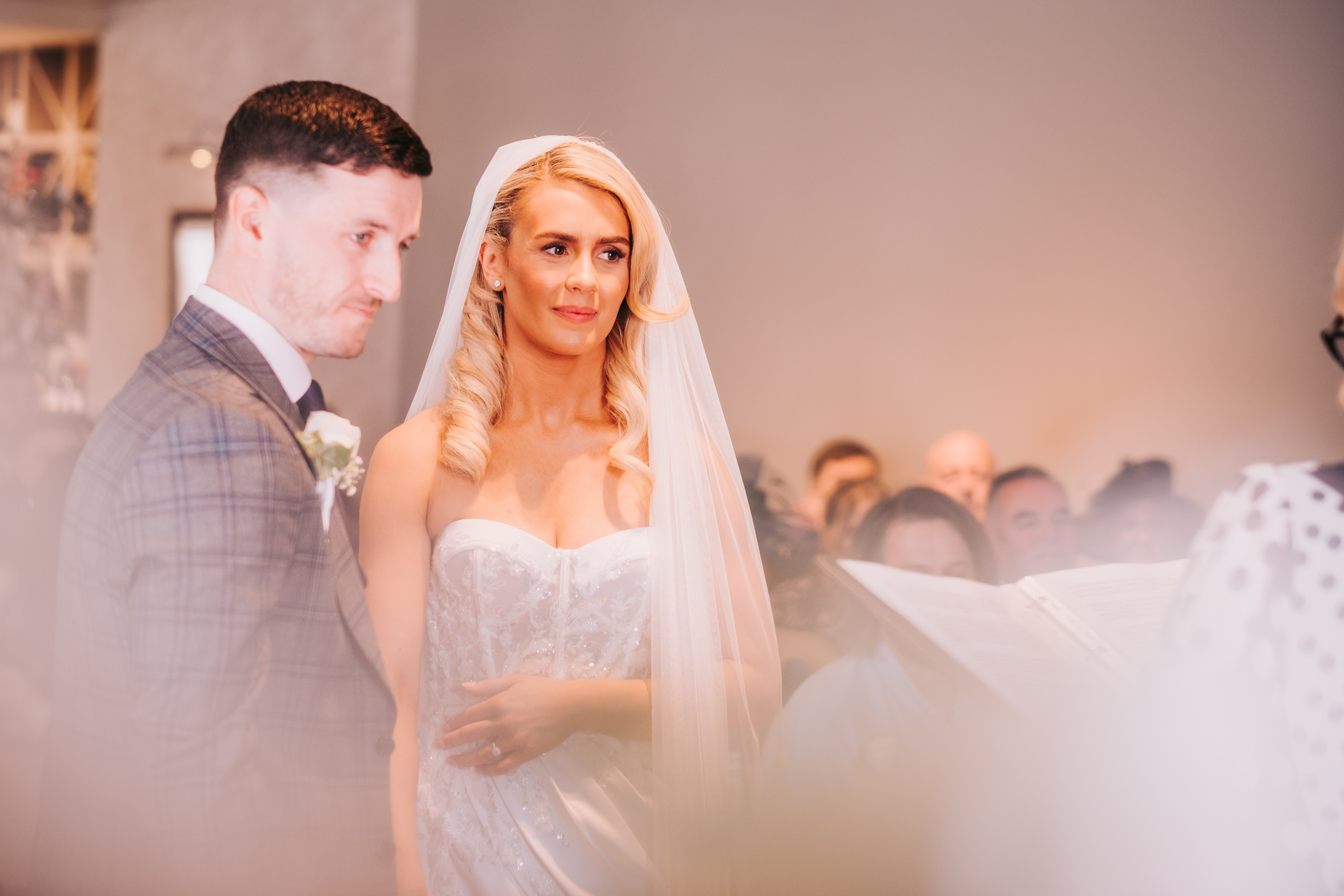 Bride and groom listening to celebrant, bride's hand at waist Bride and groom listening to celebrant, bride's hand at waist