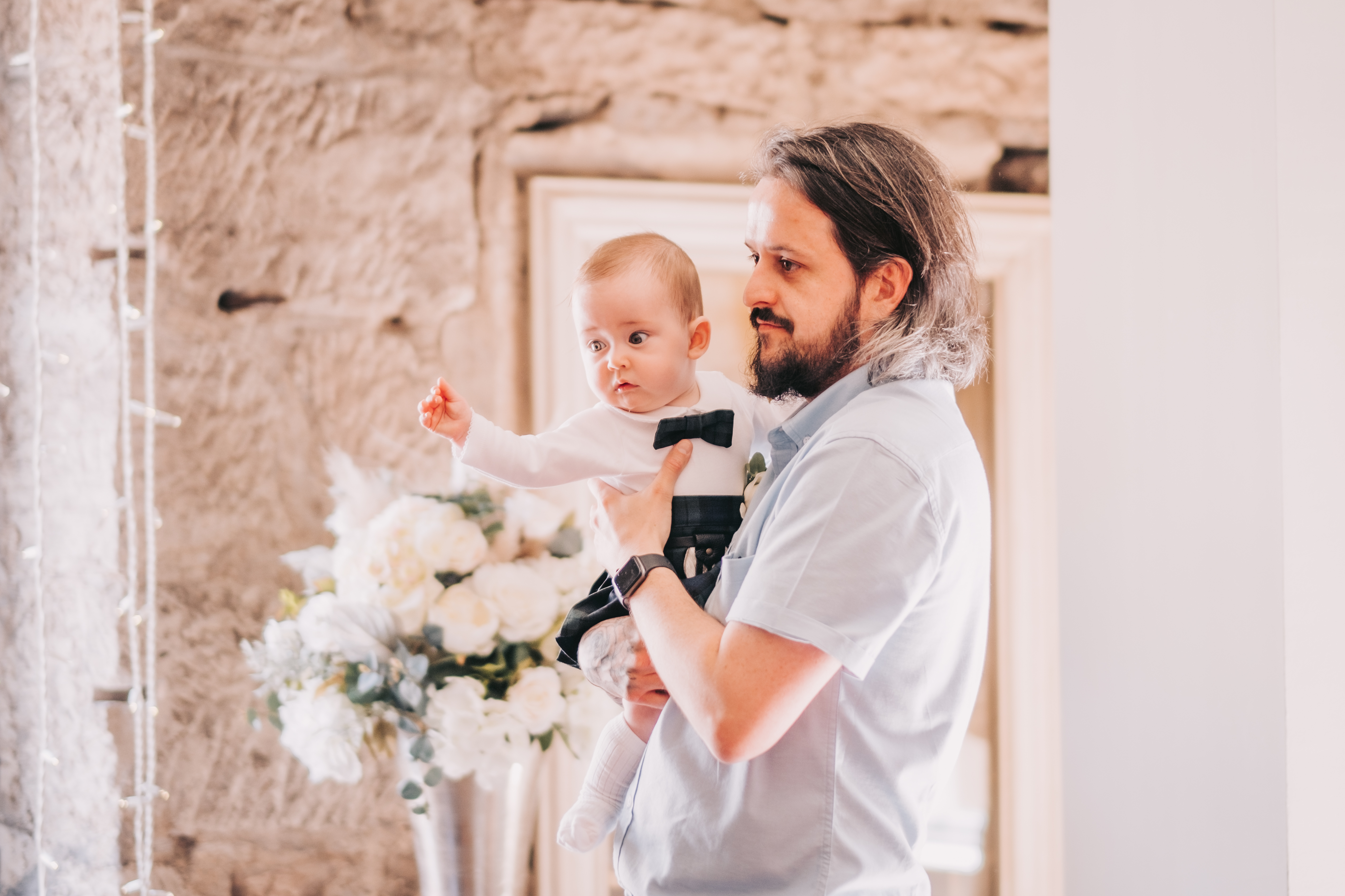 Guest holding baby in kilt and bow tie at Citation wedding ceremony, Merchant City, Glasgow Guest holding baby in kilt and bow tie at Citation wedding ceremony, Merchant City, Glasgow