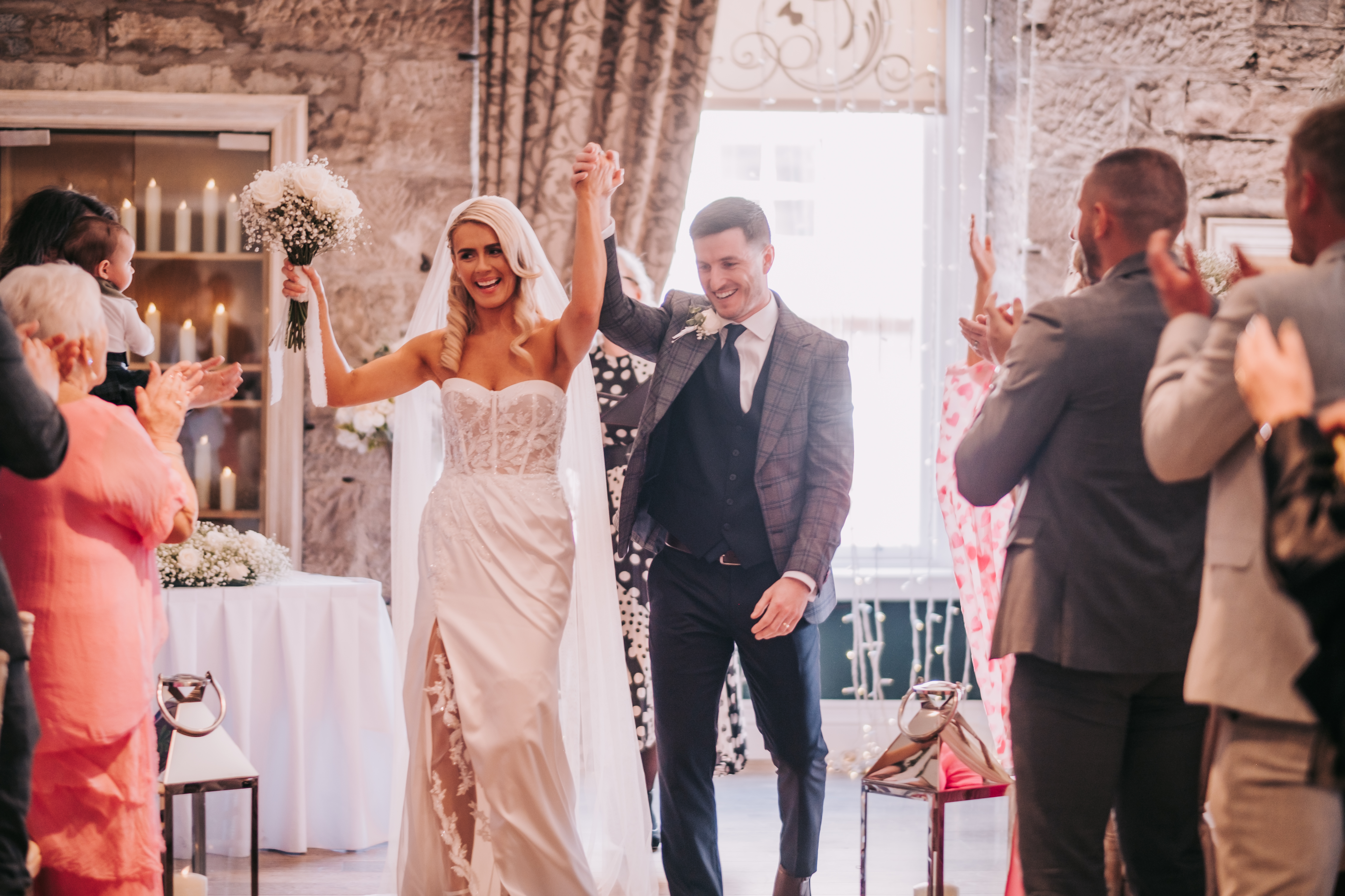 Bride and groom celebrating with hands raised at the end of their wedding ceremony. Bride and groom celebrating with hands raised at the end of their wedding ceremony.