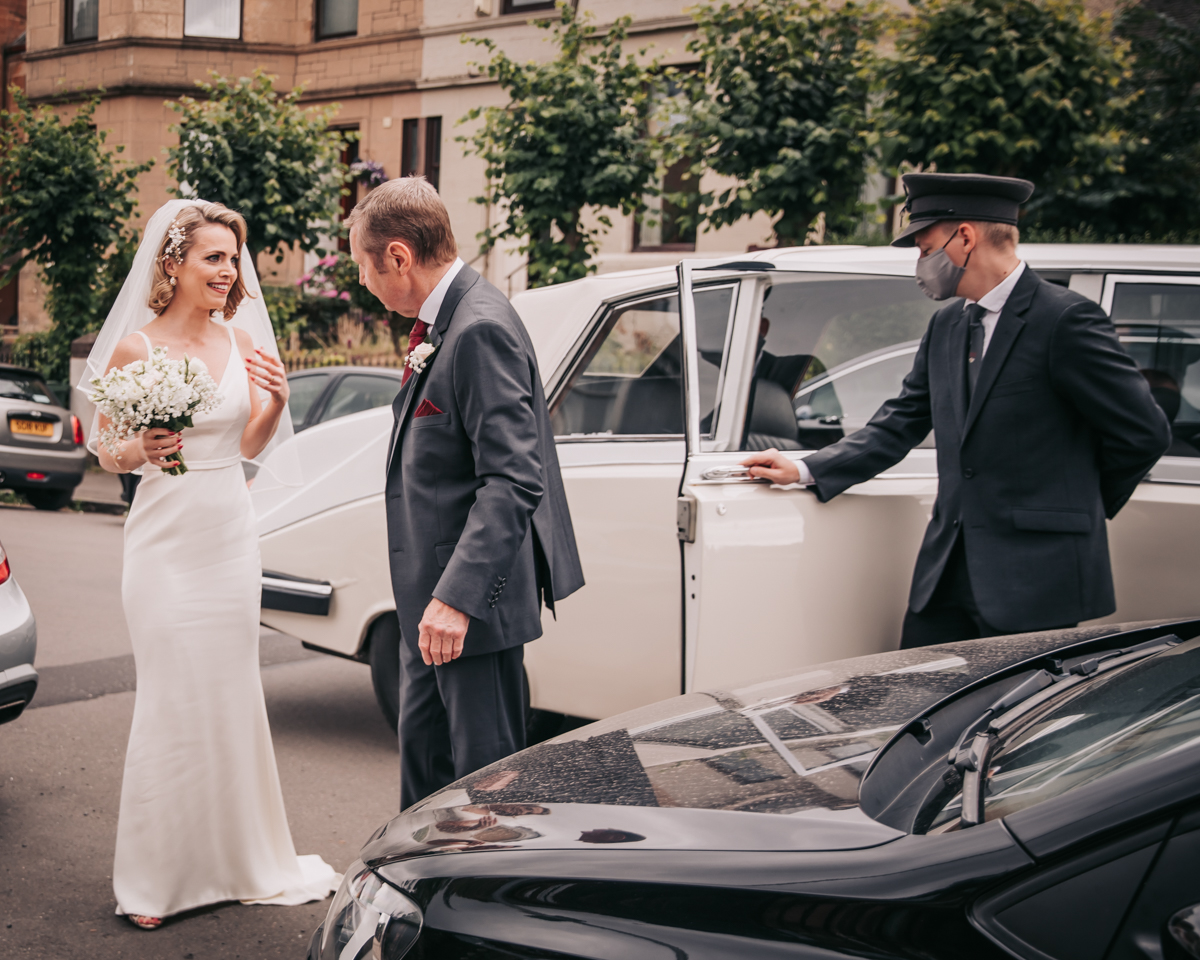 Natural moment of bride and father of the bride chatting outside wedding car ay Holy Cross Church. Natural moment of bride and father of the bride chatting outside wedding car ay Holy Cross Church.