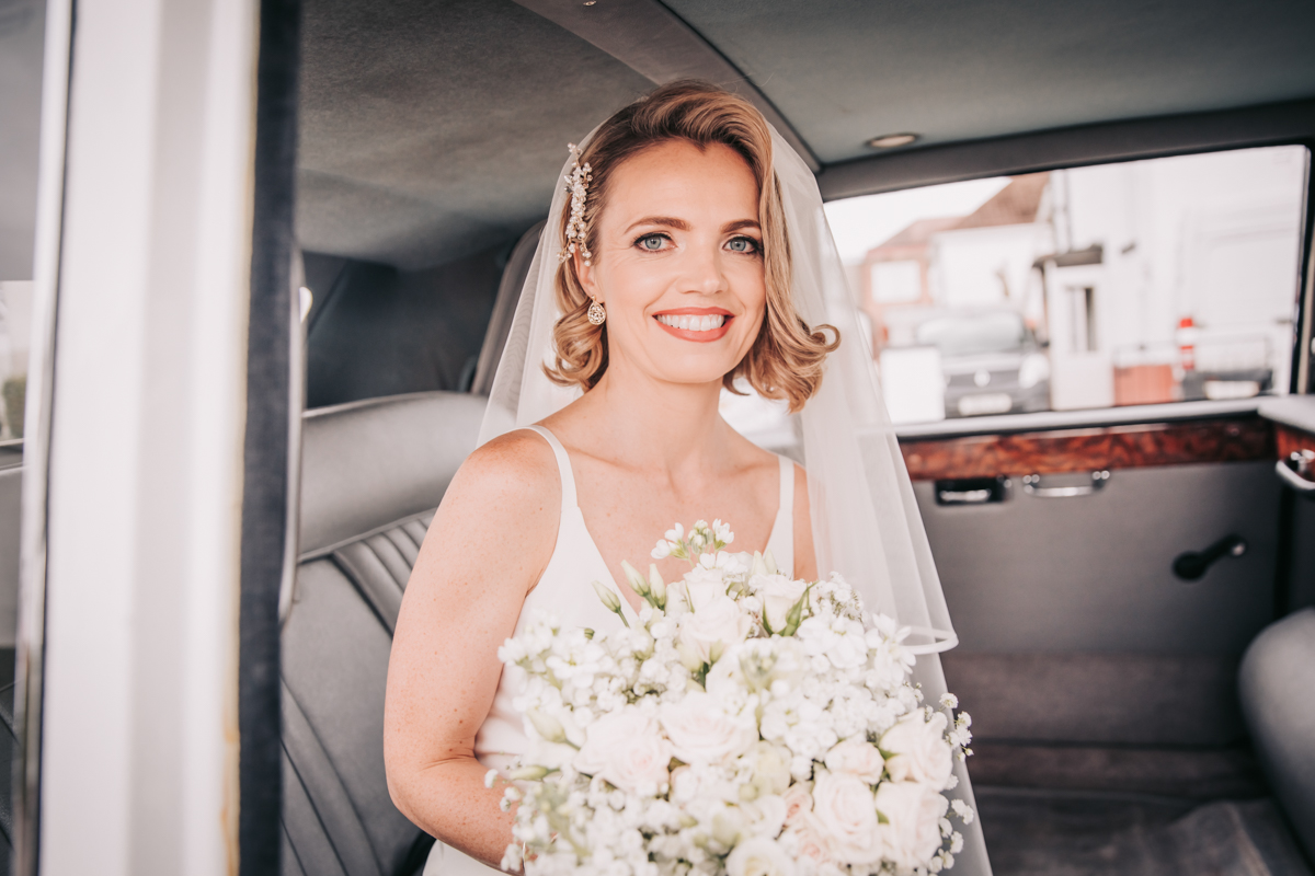 Bride with wedding bouquet in the wedding car, on the way to the church. Bride with wedding bouquet in the wedding car, on the way to the church.