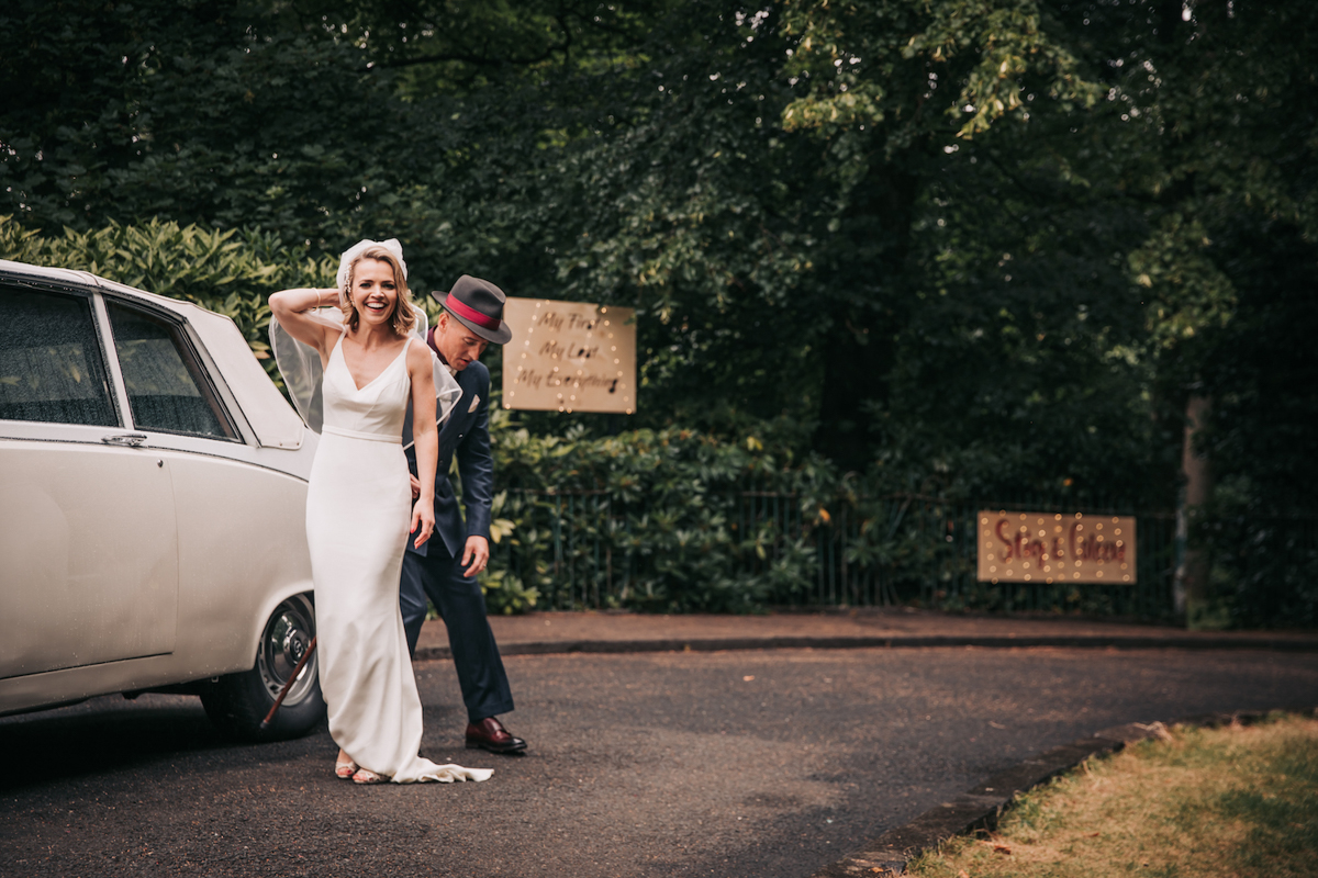 Documentary style wedding photography, groom fixing bride's dress outside Pollokshields Burgh Hall. Documentary style wedding photography, groom fixing bride's dress outside Pollokshields Burgh Hall.