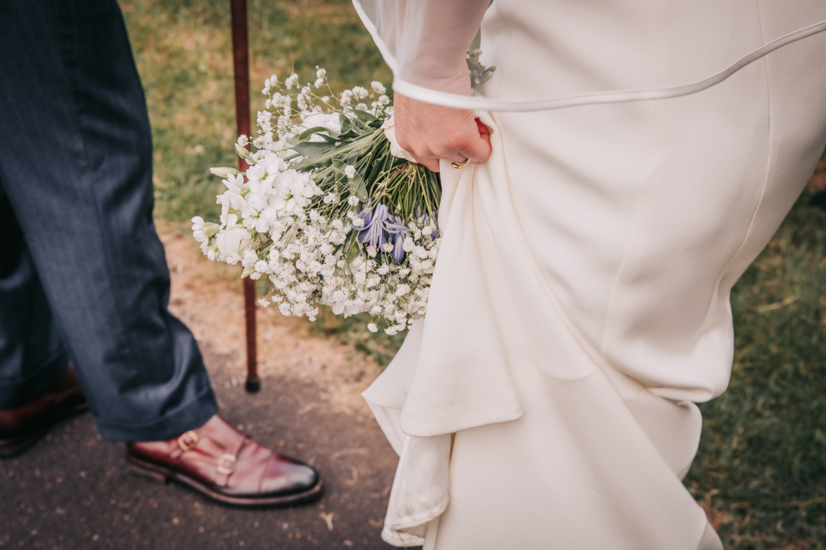Bride clutching wedding dress, floral bouquet. Bride clutching wedding dress, floral bouquet.