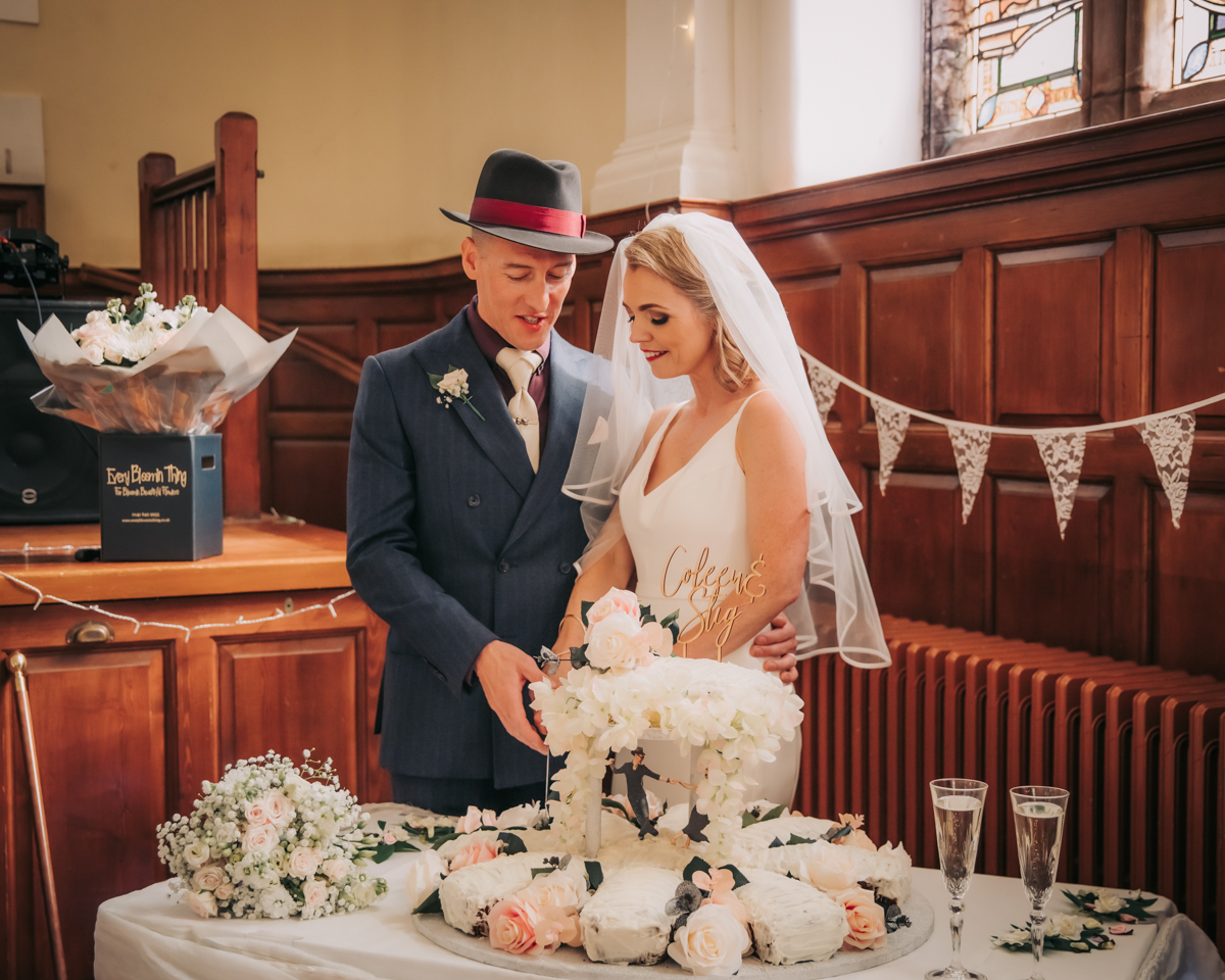 Bride and groom cutting cake during evening reception, Pollokshields Burgh Hall. Bride and groom cutting cake during evening reception, Pollokshields Burgh Hall.