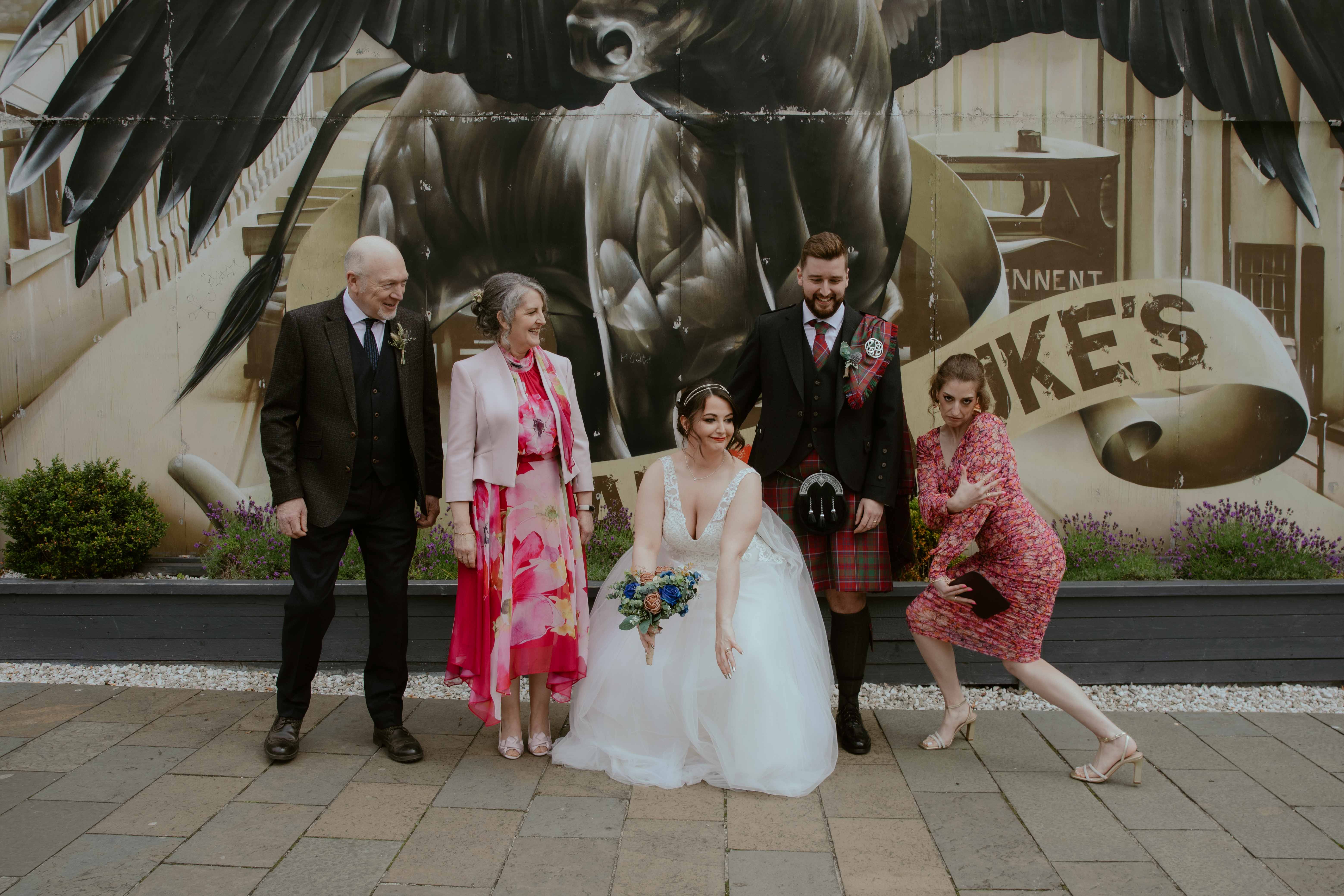 Group shot with Bride and Groom and Groom's family in front of Winged Ox Mural, Saint Luke's, Glasgow. Group shot with Bride and Groom and Groom's family in front of Winged Ox Mural, Saint Luke's, Glasgow.