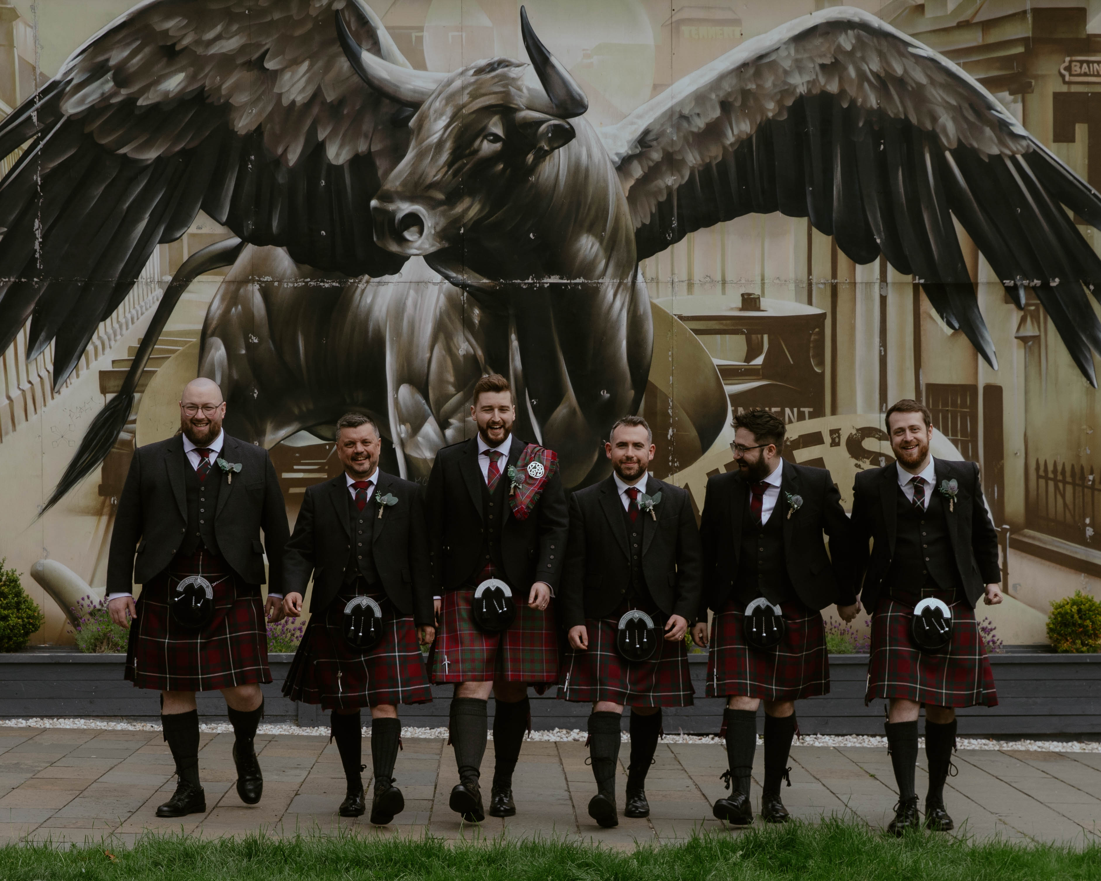 Groom and Groomsmen walking forwards in front of Winged Ox Mural, Saint Luke's, Glasgow. Groom and Groomsmen walking forwards in front of Winged Ox Mural, Saint Luke's, Glasgow.