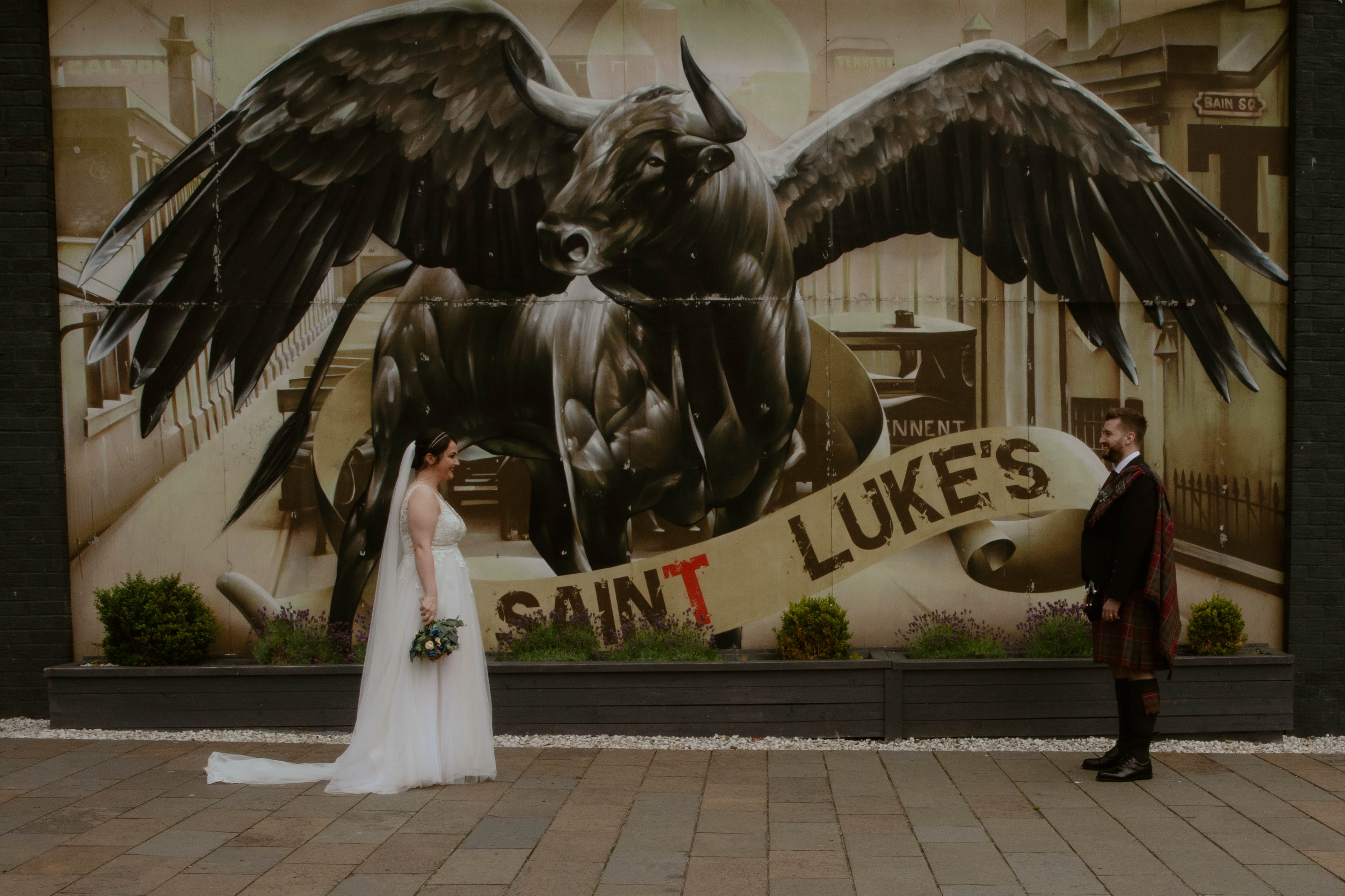 Bride and Groom in front of the Winged Ox Mural, Saint Luke's, Glasgow. Bride and Groom in front of the Winged Ox Mural, Saint Luke's, Glasgow.