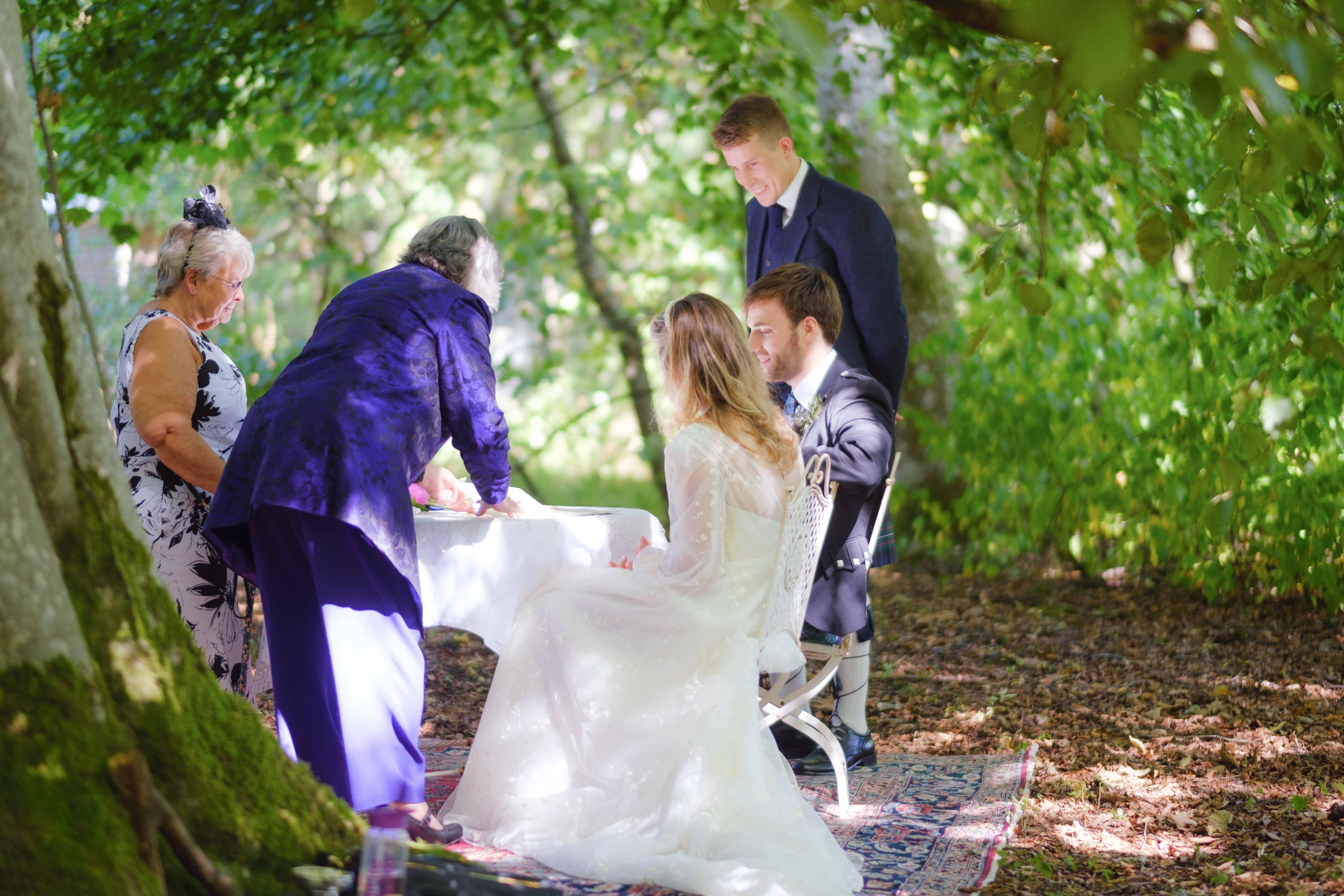 Bride and groom during signing of the register with two witnesses and celebrant. Bride and groom during signing of the register with two witnesses and celebrant.
