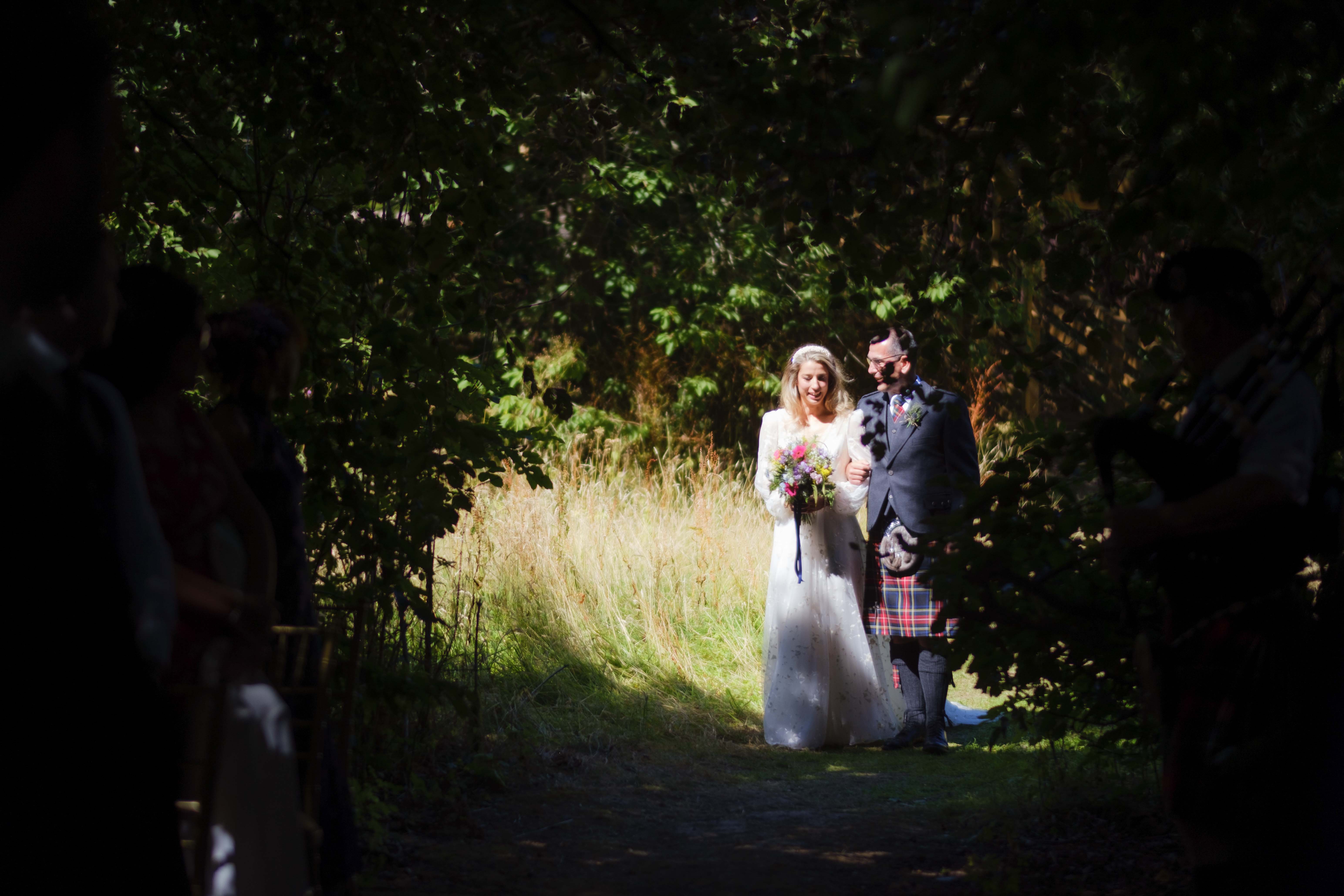 Bride and father of the bride walking through trees to outdoor ceremony, Kippilaw House, Scottish Borders. Bride and father of the bride walking through trees to outdoor ceremony, Kippilaw House, Scottish Borders.