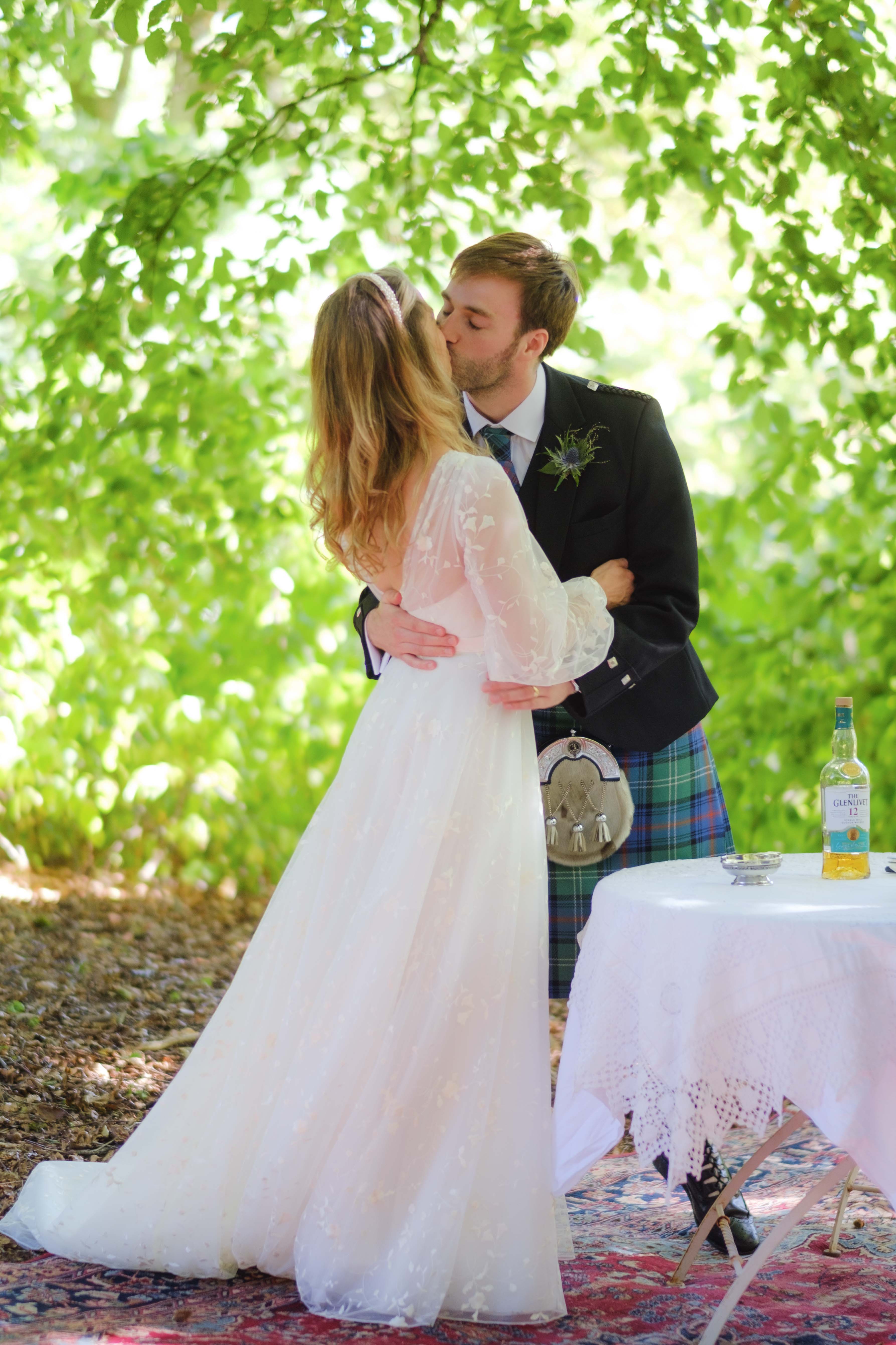 Bride and groom's first kiss during their outdoor wedding ceremony at Kippilaw House. Bride and groom's first kiss during their outdoor wedding ceremony at Kippilaw House.