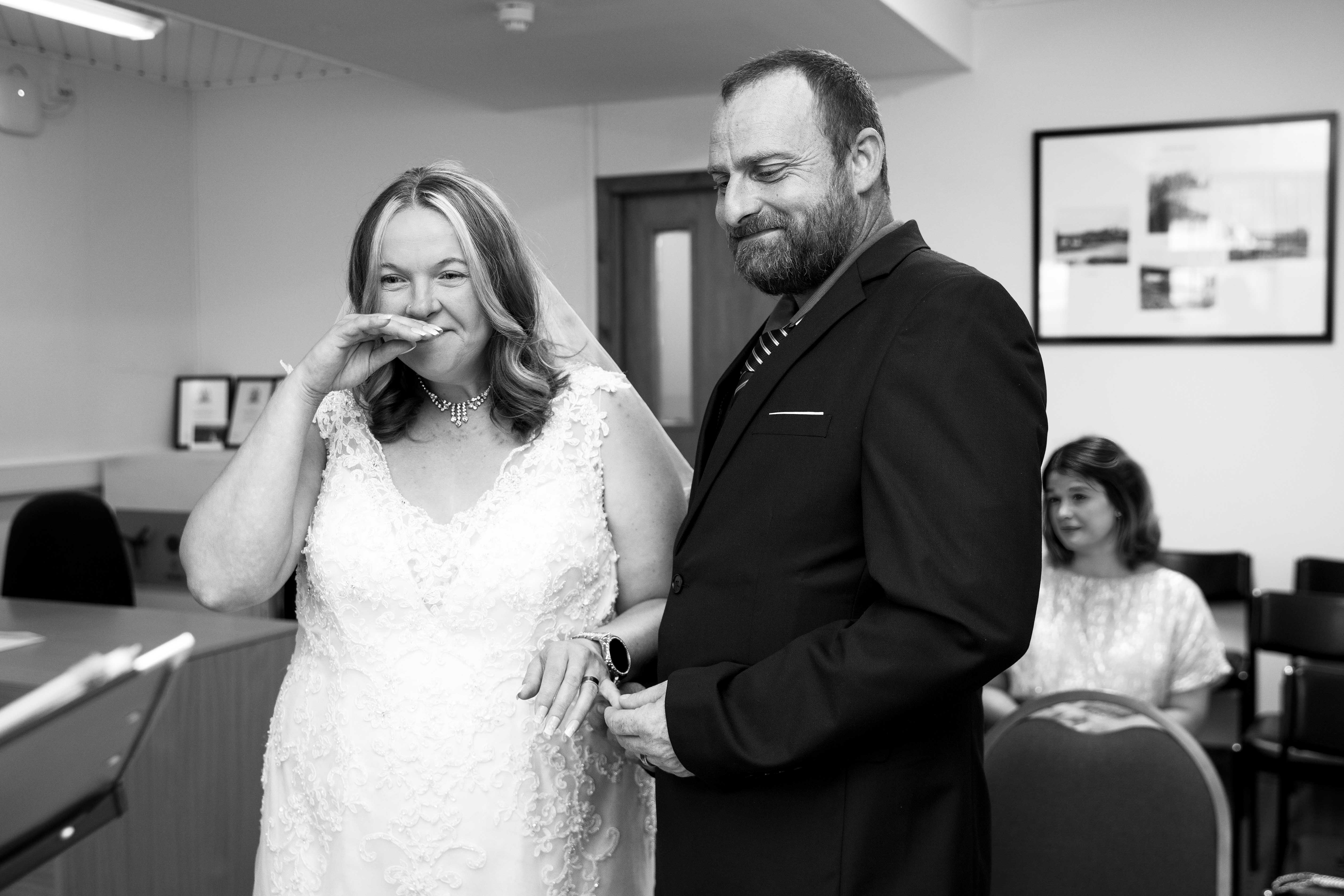 Bride and groom during wedding ceremony at Newton Stewart Registry Office, smiling as vows are read Bride and groom during wedding ceremony at Newton Stewart Registry Office, smiling as vows are read