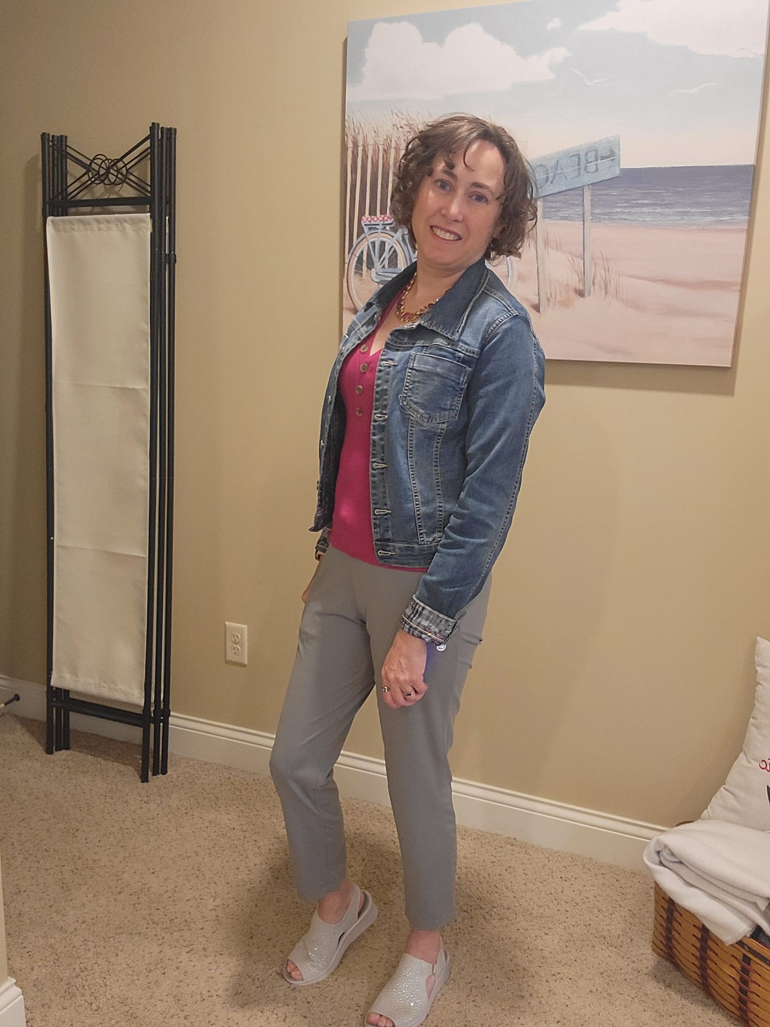Jenn styled in a denim jacket over a bright pink sleeveless LOFT top, paired with gray G Gradual pants for a vibrant and casual everyday look.