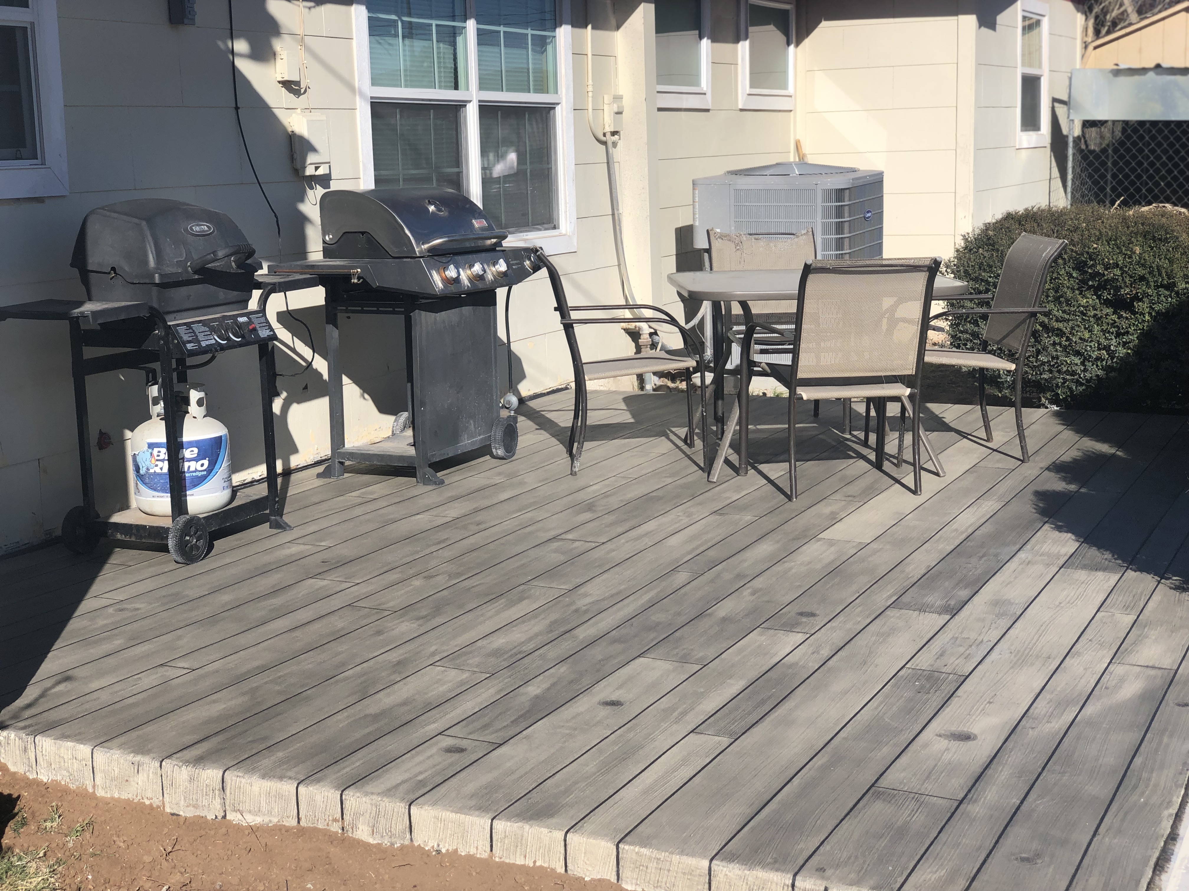 Grey weathered concrete wood decorative patio overlay in Odessa TX