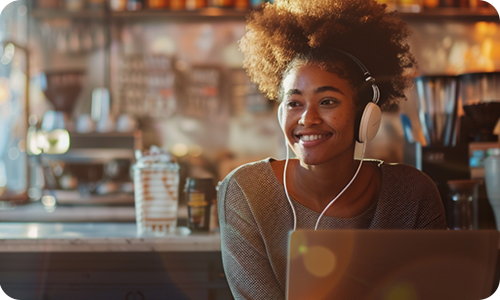 A young African American woman listens to an audiobook in a cafe A young African American woman listens to an audiobook in a cafe