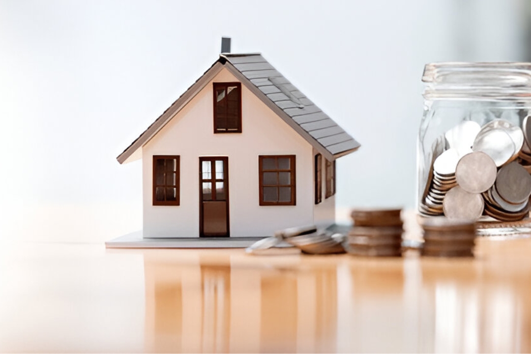 A miniature house stands beside a jar of coins and stacks of cash, representing owner financing homes from KBR Investing. A miniature house stands beside a jar of coins and stacks of cash, representing owner financing homes from KBR Investing.