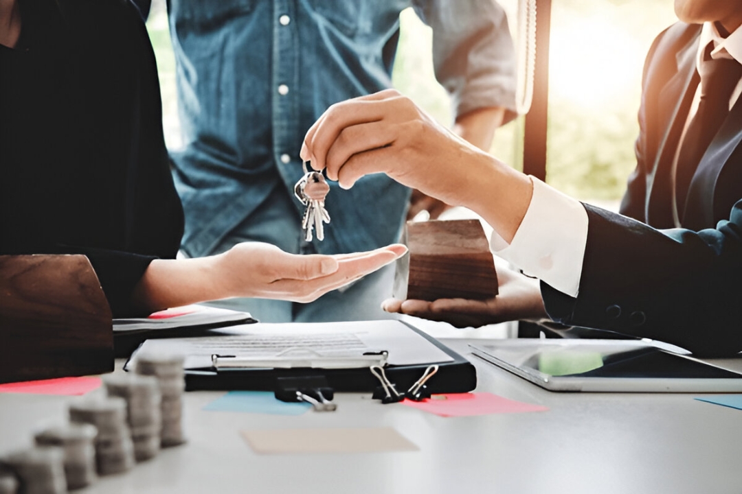  A hand receives house keys over a contract, enabling you to Buy a house with owner financing from KBR Investing.