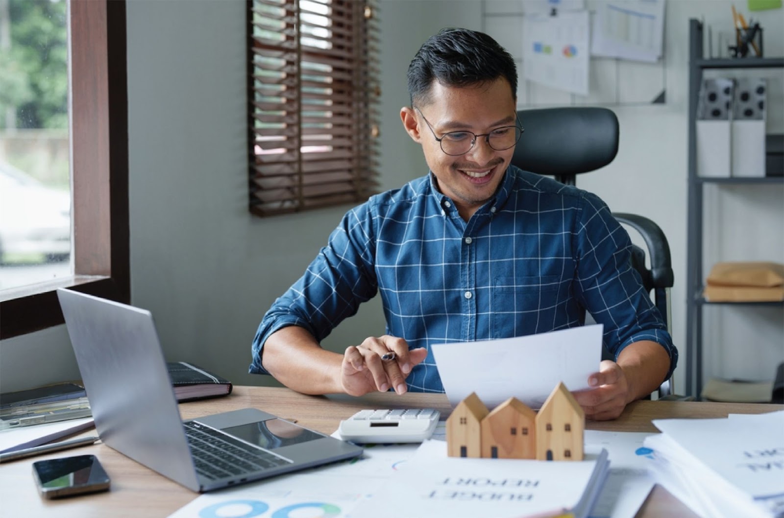A person works at a desk with a laptop and house models, representing Owner financing for people denied by banks at KBR Investing. A person works at a desk with a laptop and house models, representing Owner financing for people denied by banks at KBR Investing.
