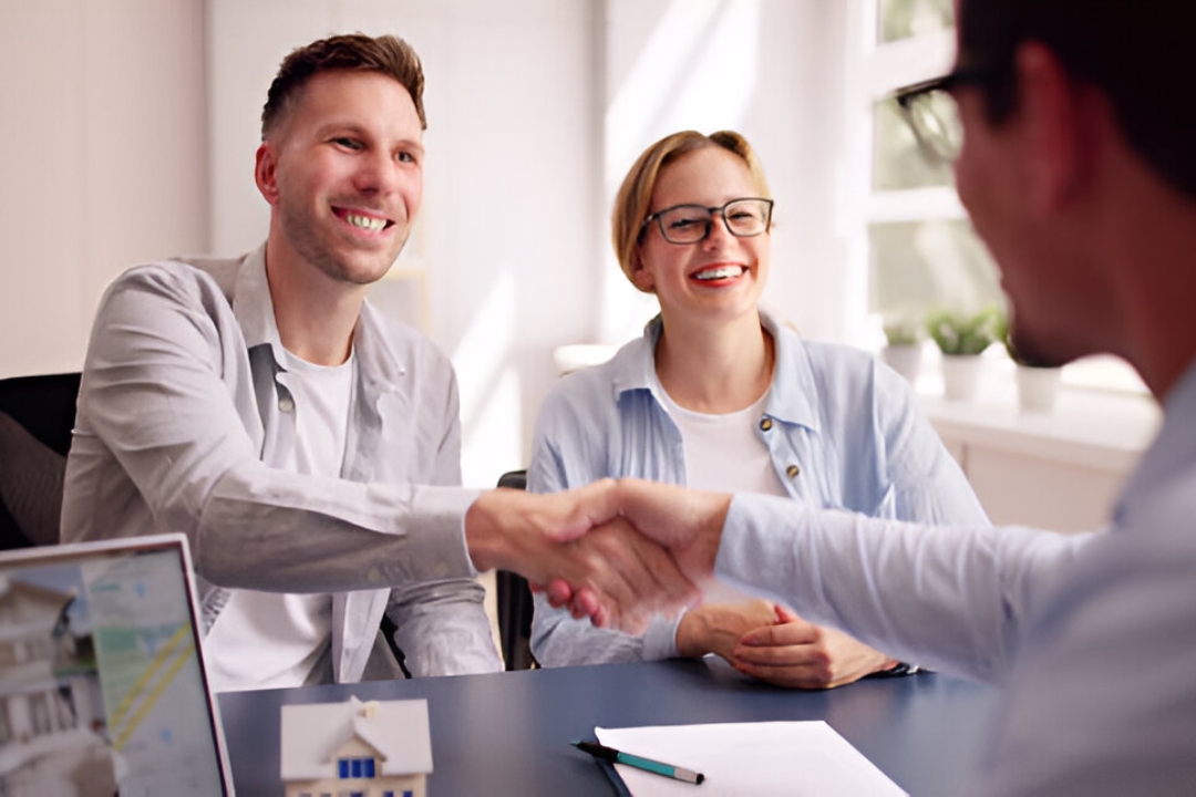 A man and woman shaking hands with a financial advisor over a house model and laptop, offering Financing solutions for low credit scores from KBR Investing. A man and woman shaking hands with a financial advisor over a house model and laptop, offering Financing solutions for low credit scores from KBR Investing.
