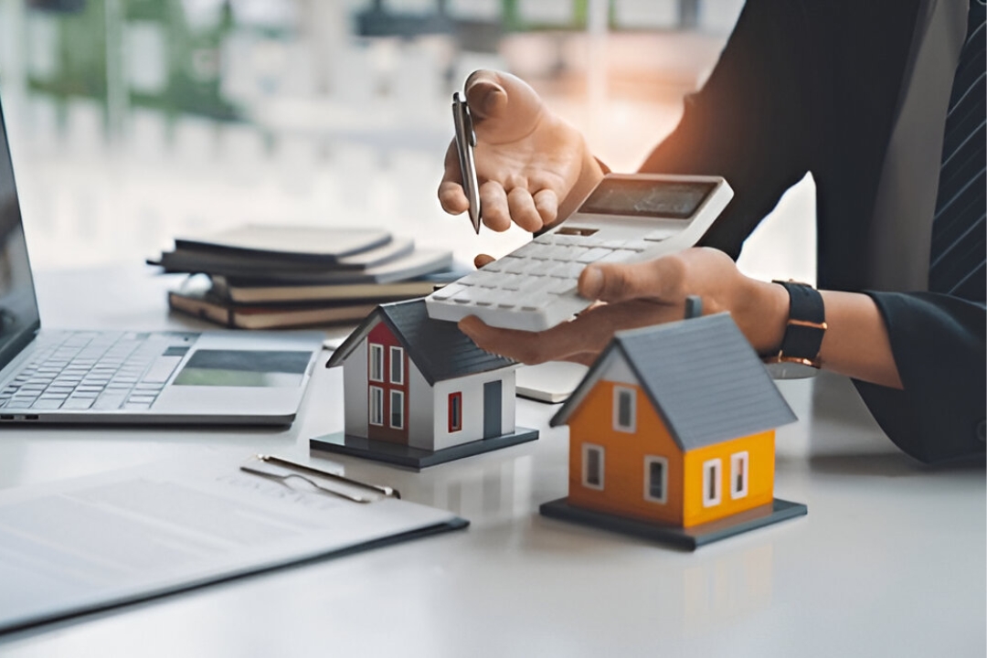 A financial advisor with model houses and a calculator, explaining how to Buy a home without a bank through KBR Investing. A financial advisor with model houses and a calculator, explaining how to Buy a home without a bank through KBR Investing.