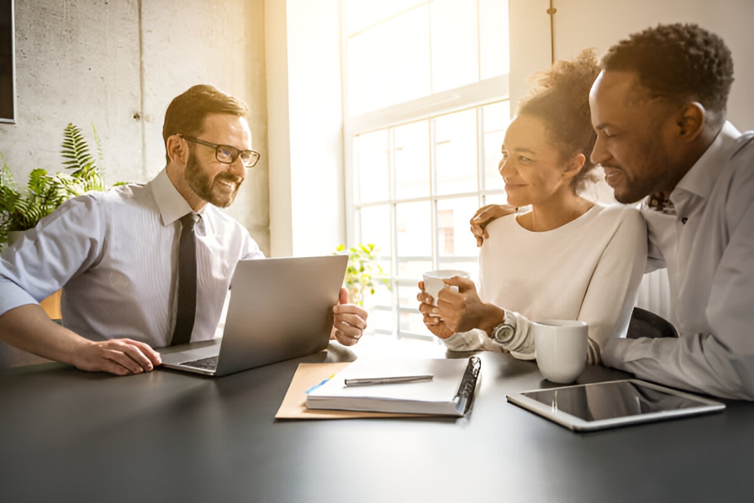  A diverse couple meets with a financial advisor, exploring Alternative financing for homes from KBR Investing.