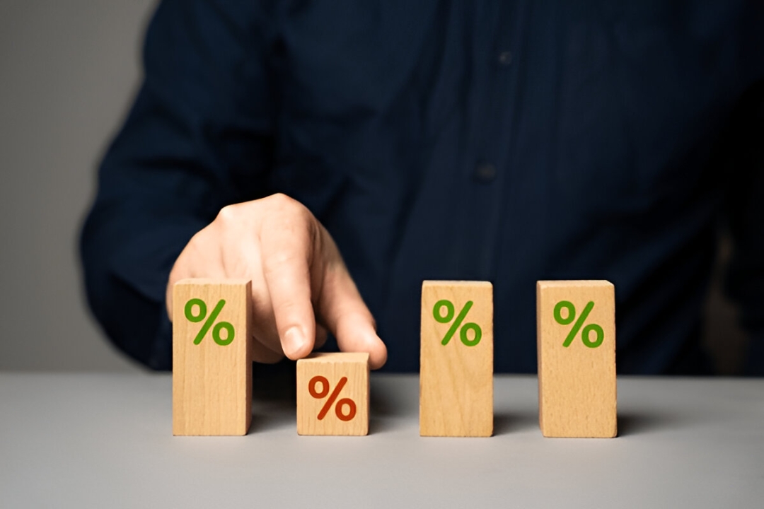 Wooden blocks with green percentage signs and one red, symbolizing interest rates for a work visa home loan by Kbr Investing.