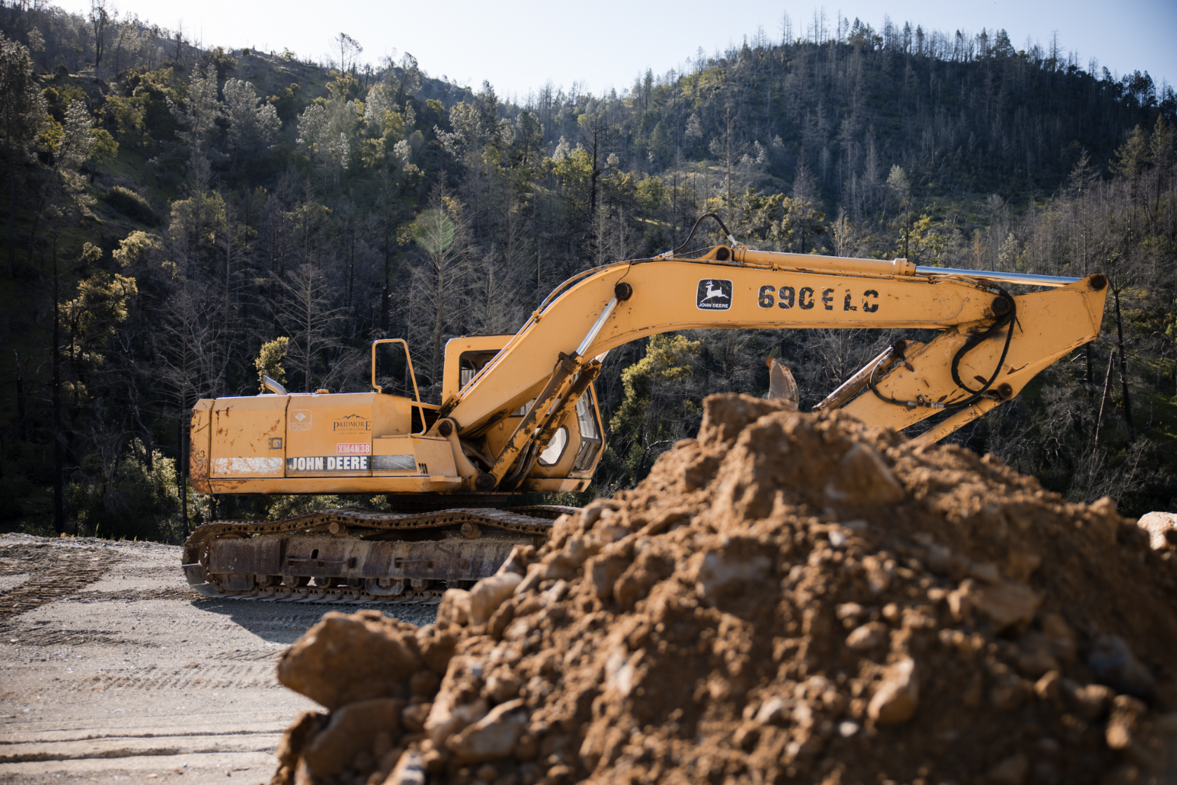 Excavator leveling soil for site preparation by Pridmore Construction in Napa Valley.