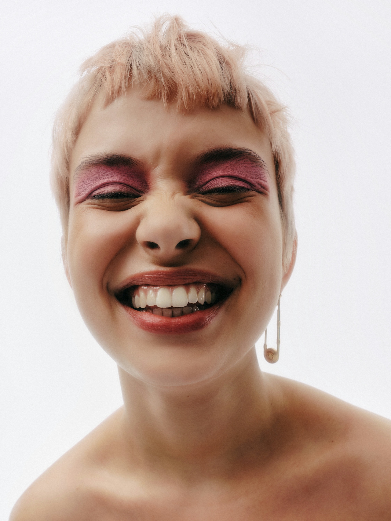 a woman with short blond hair laughing a woman with short blond hair laughing