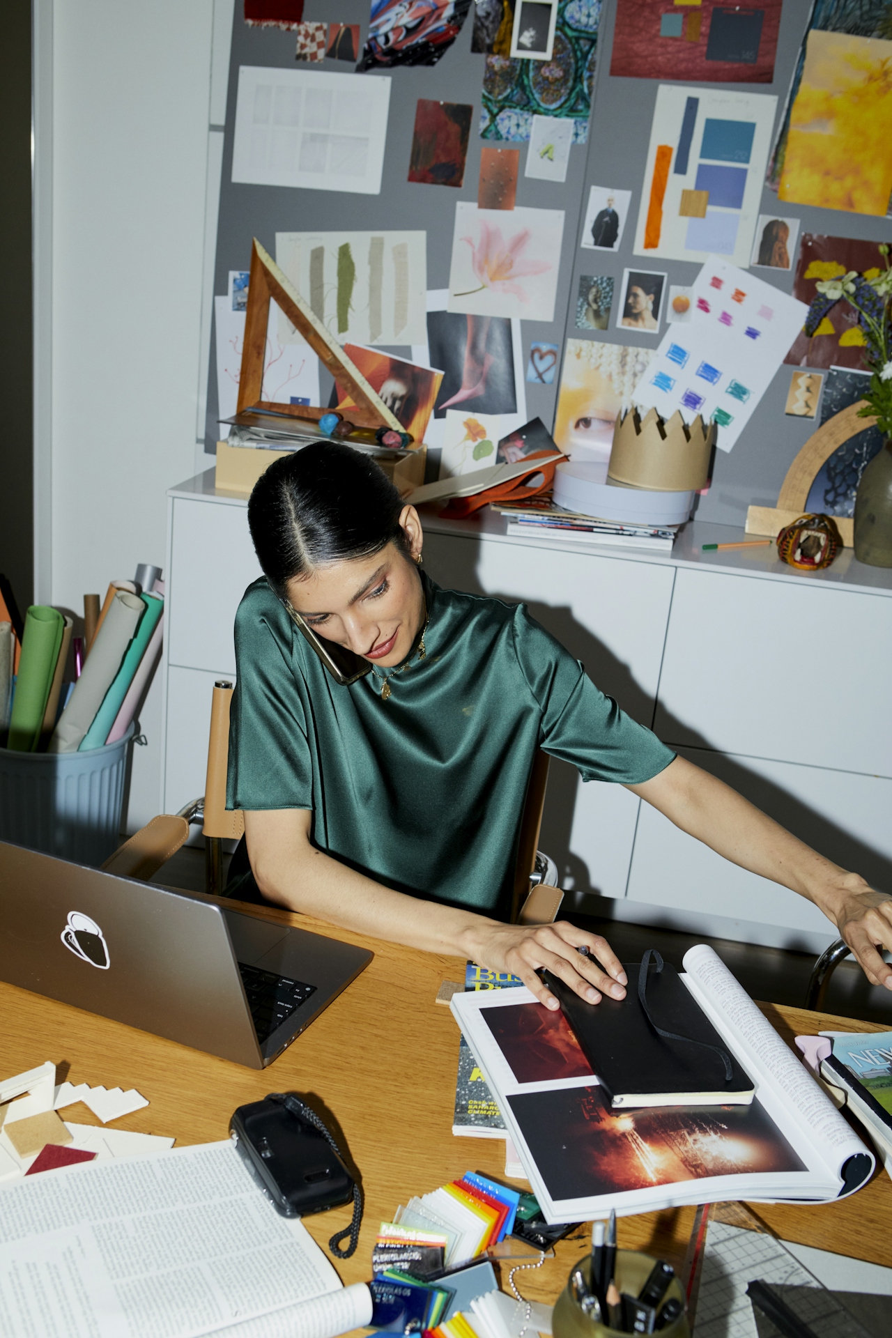 a Middle Eastern woman sitting at a desk talking on the phone in her office. a Middle Eastern woman sitting at a desk talking on the phone in her office.