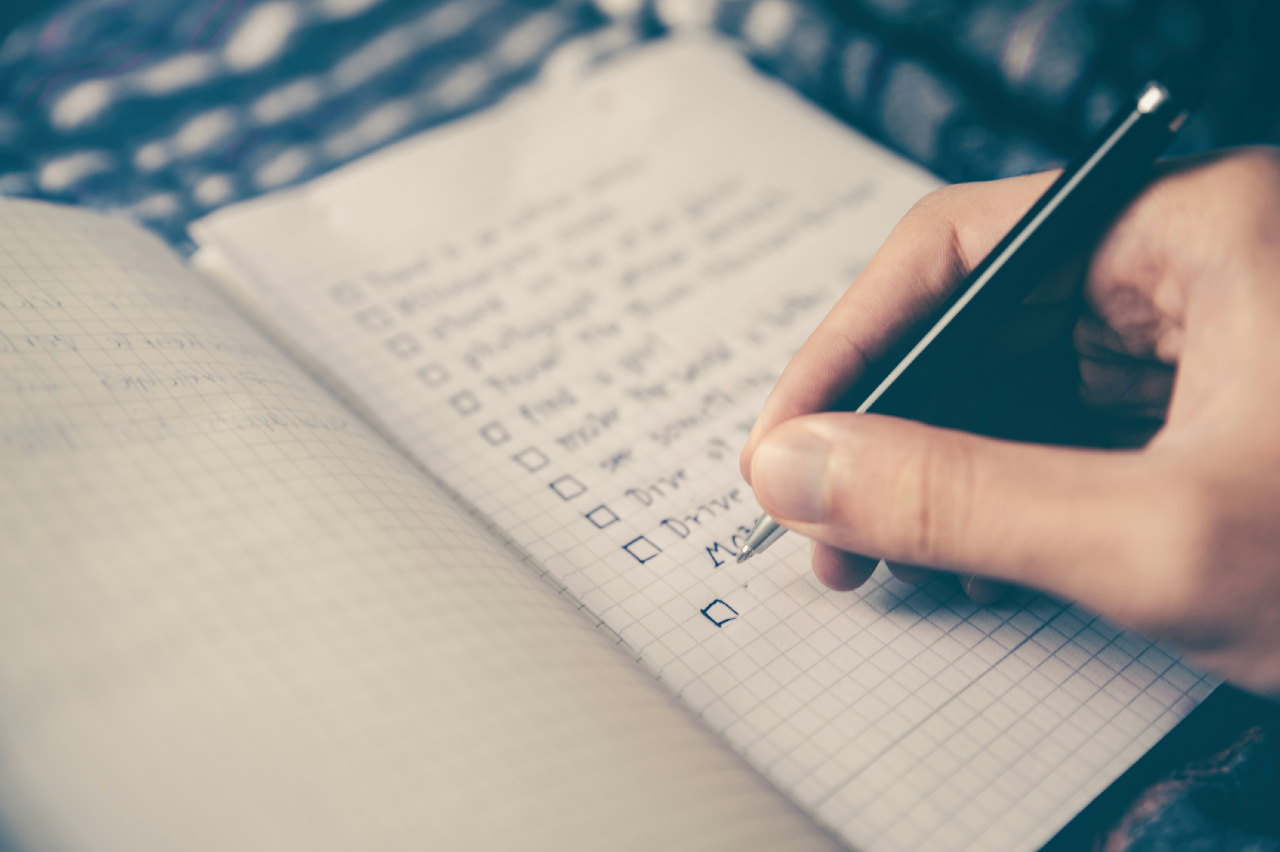 Man writing a checklist in a bullet journal Man writing a checklist in a bullet journal