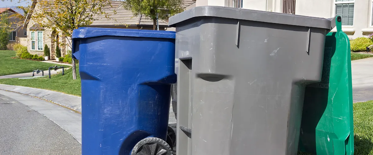 lue, gray, and green trash bins ready for exterior cleaning lue, gray, and green trash bins ready for exterior cleaning
