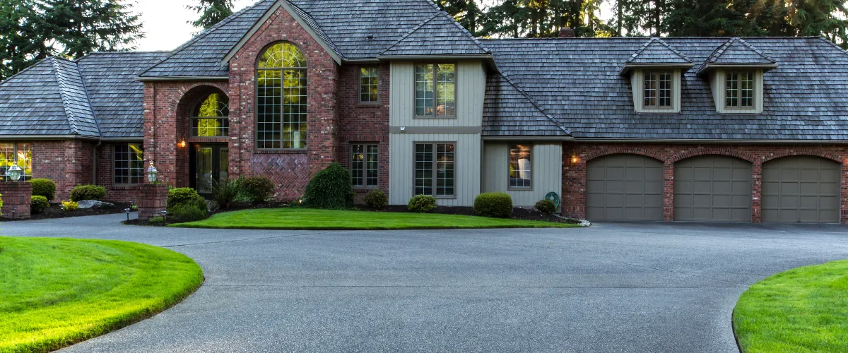 Large brick home with a clean, well-maintained concrete driveway Large brick home with a clean, well-maintained concrete driveway