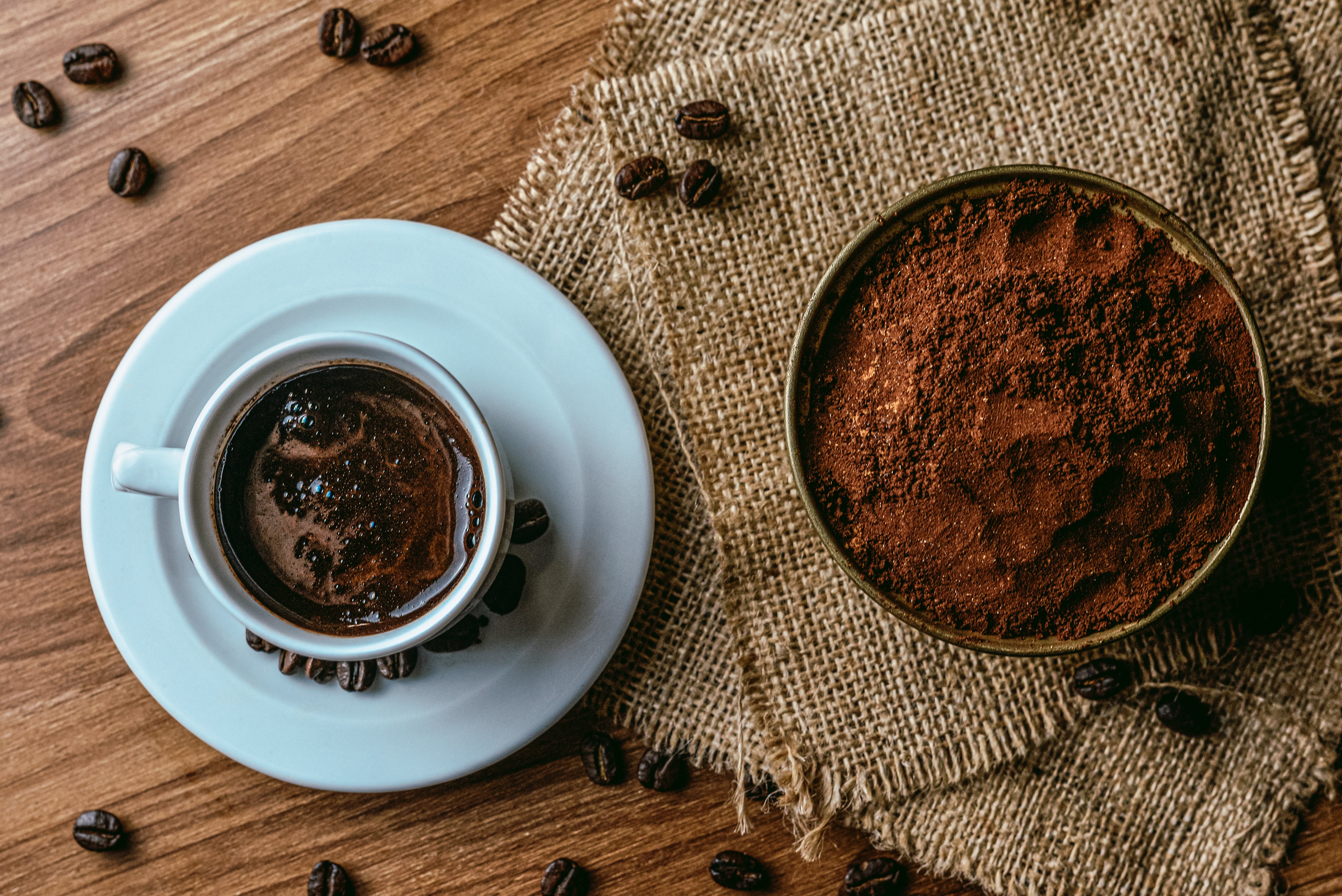 Cup of Coffee Next to Cup of Grinds