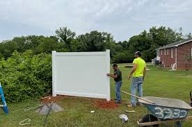 two men putting up a vinyl fence two men putting up a vinyl fence
