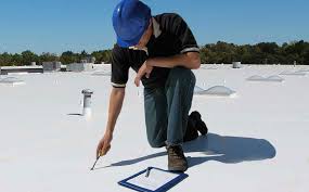 a man on top of a roof inspecting it a man on top of a roof inspecting it