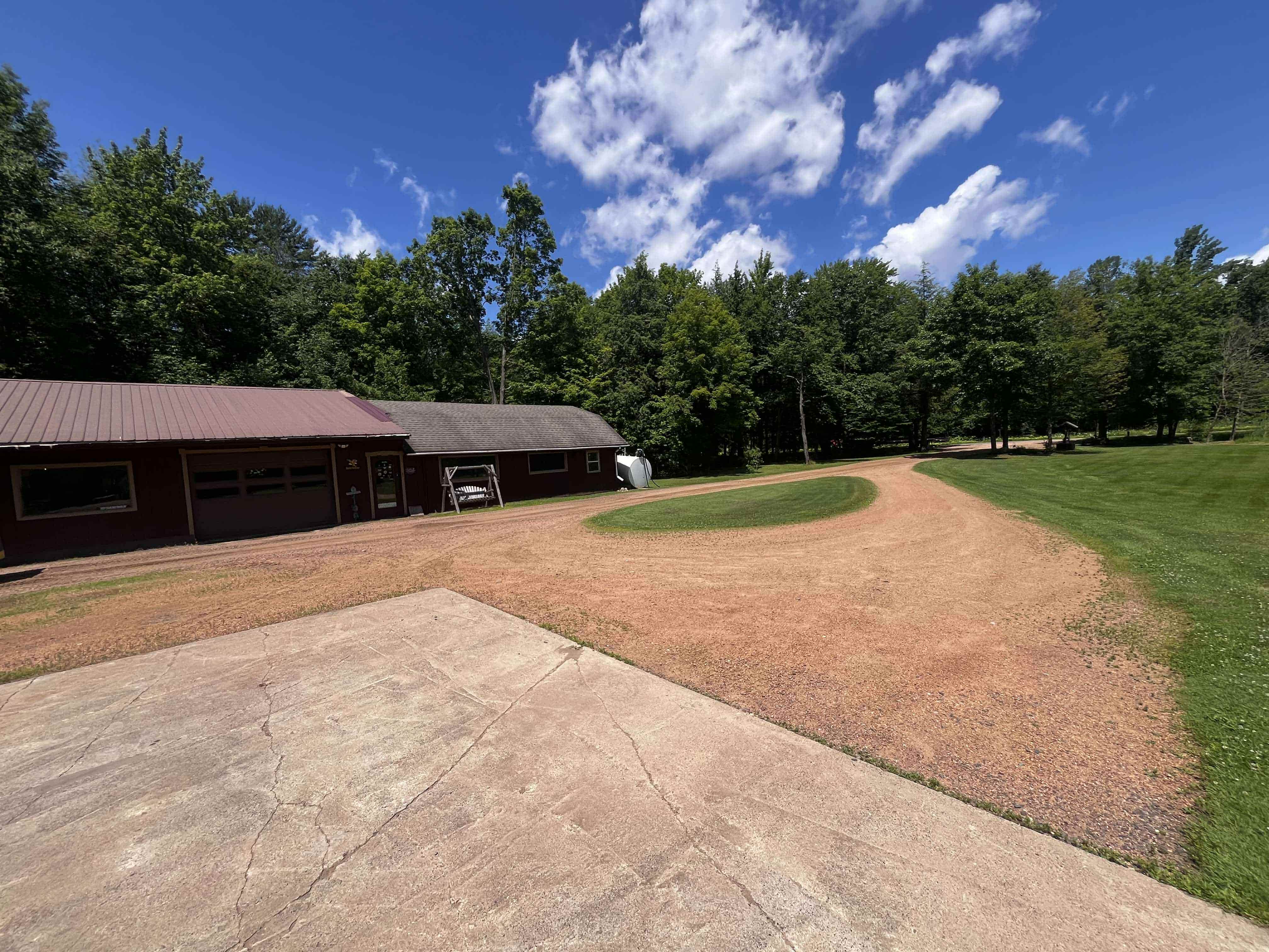 Before photo of a damaged gravel driveway in Stetsonville WI showing deep ruts and poor drainage.