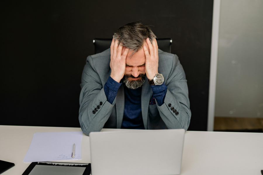 A stressed CEO at a cluttered desk, illustrating how poor mental input impairs leadership performance. A stressed CEO at a cluttered desk, illustrating how poor mental input impairs leadership performance.