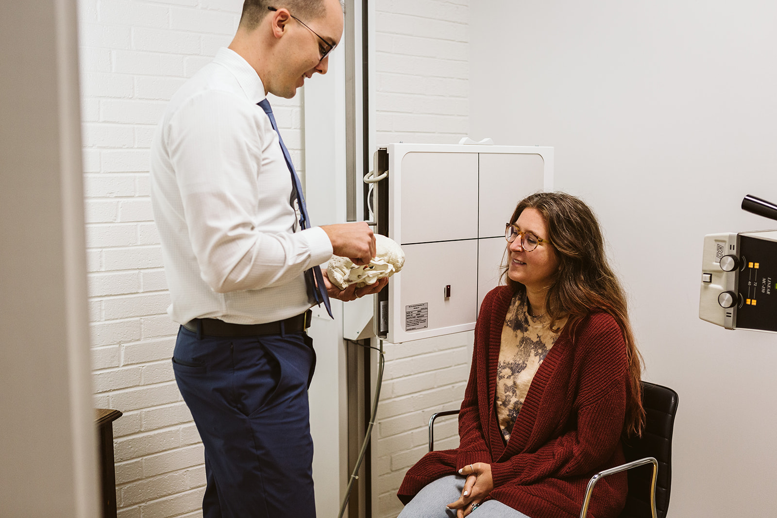 Dr. Collins explaining upper cervical correction with spine model