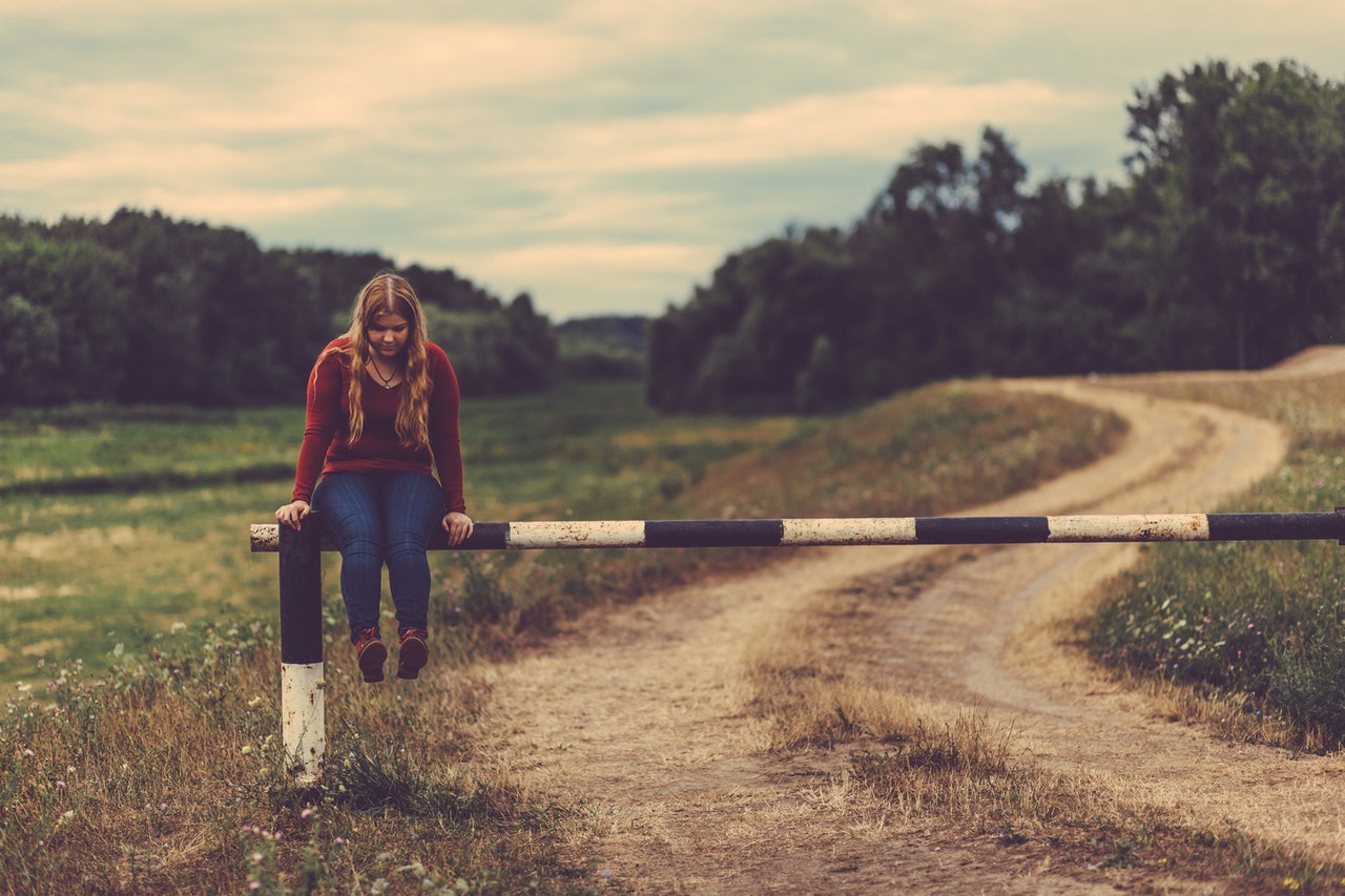 Girl sits on a fence gate Girl sits on a fence gate