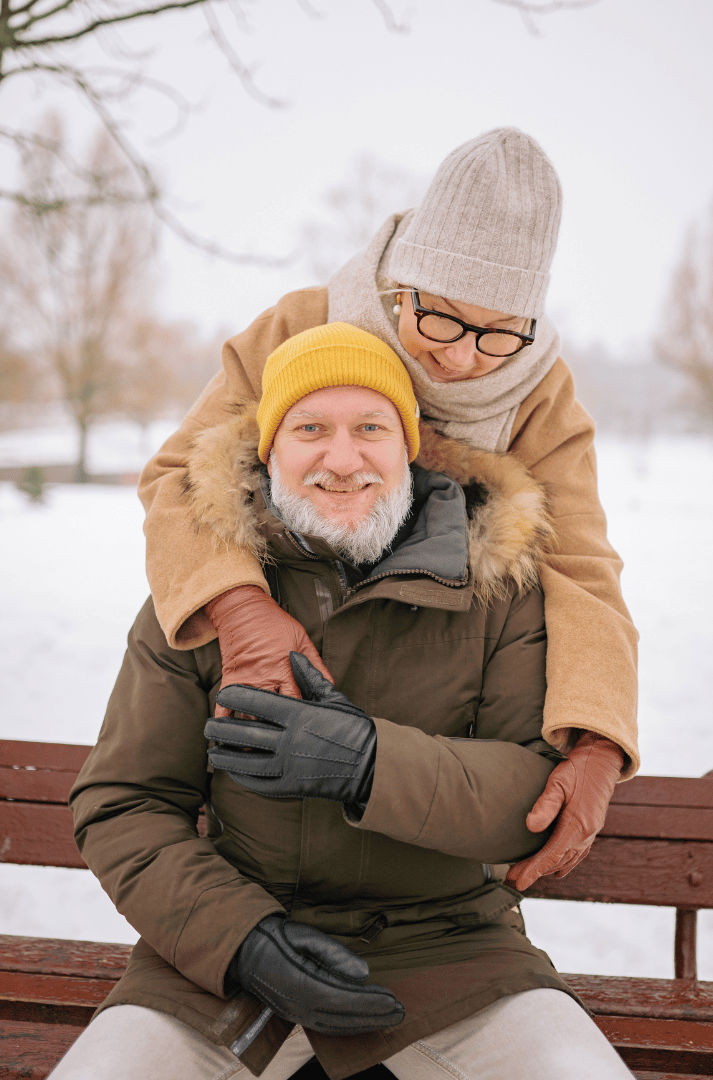 Two seniors dressed warmly with a hat, scarf, gloves, and cozy layers for winter season Two seniors dressed warmly with a hat, scarf, gloves, and cozy layers for winter season