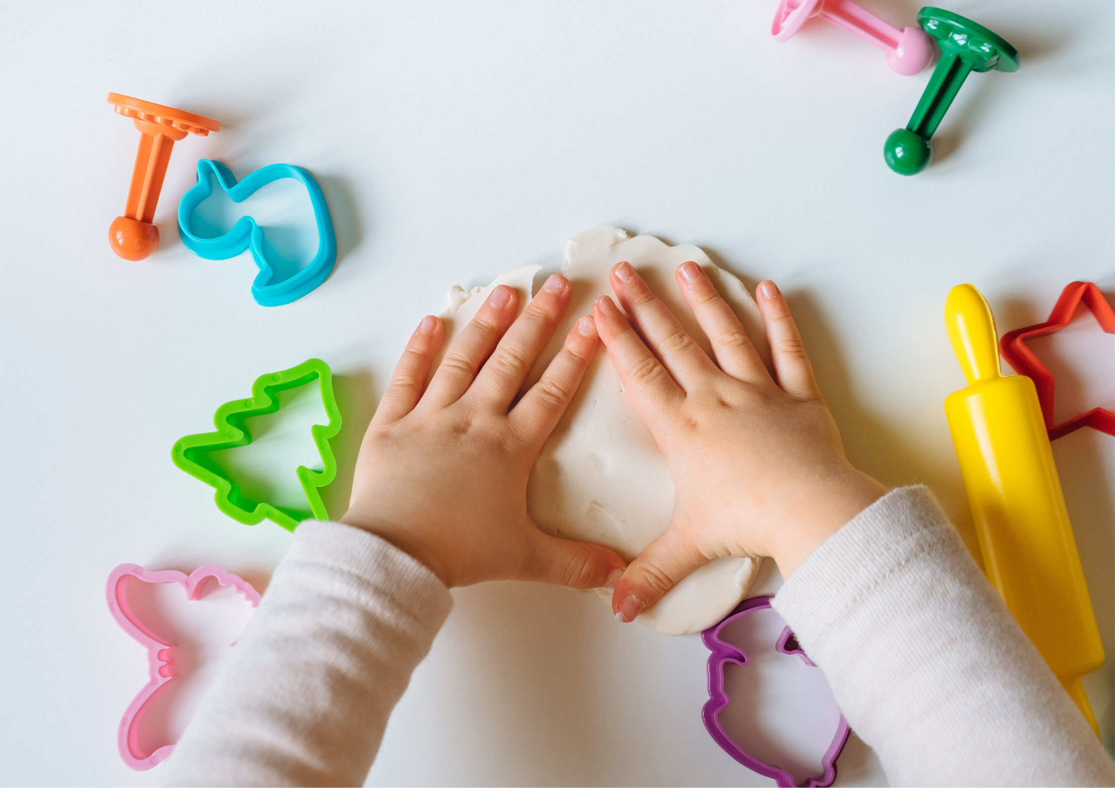 Children playing a cooperative play-dough game Children playing a cooperative play-dough game