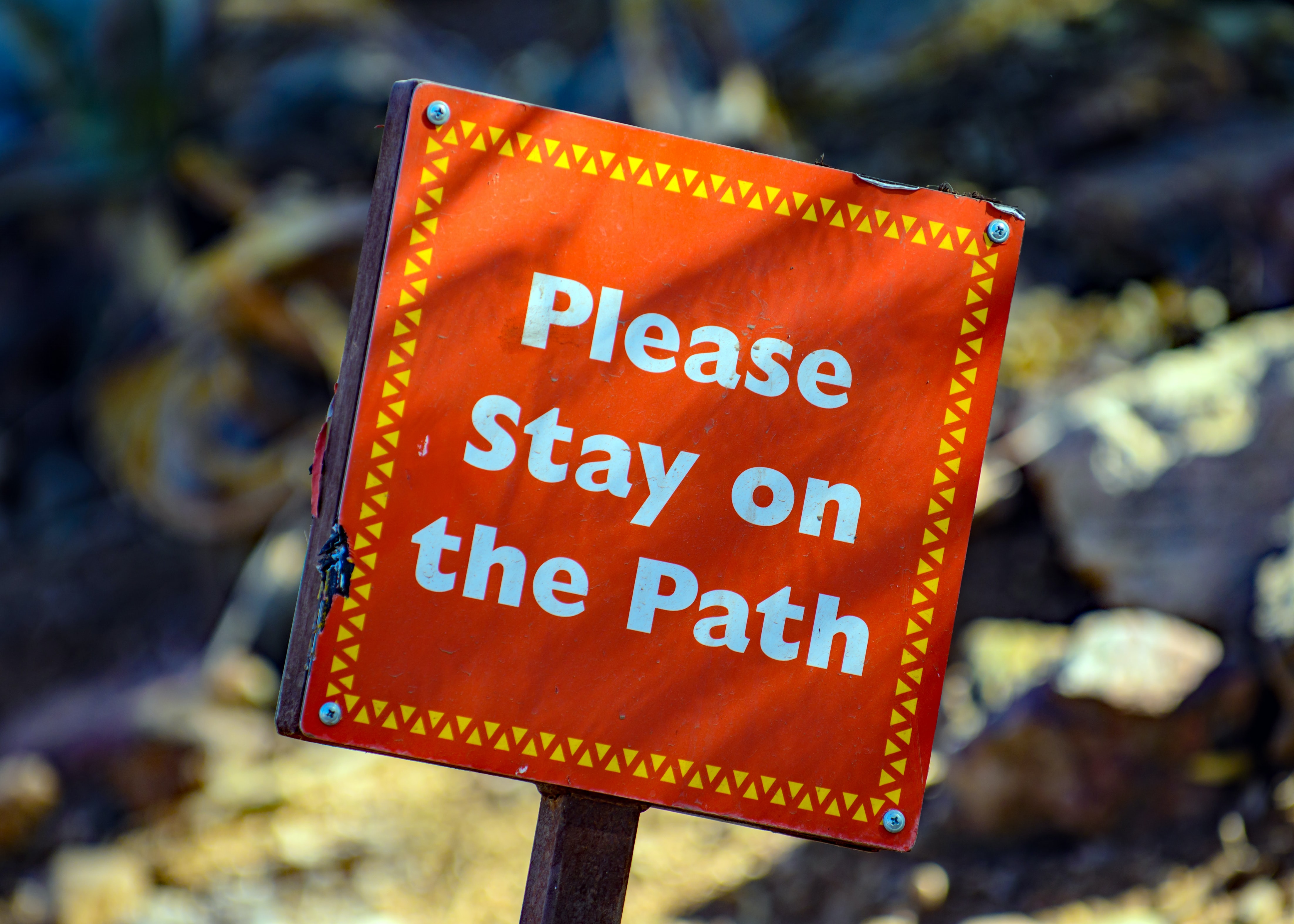A sign that says stay on the path A sign that says stay on the path