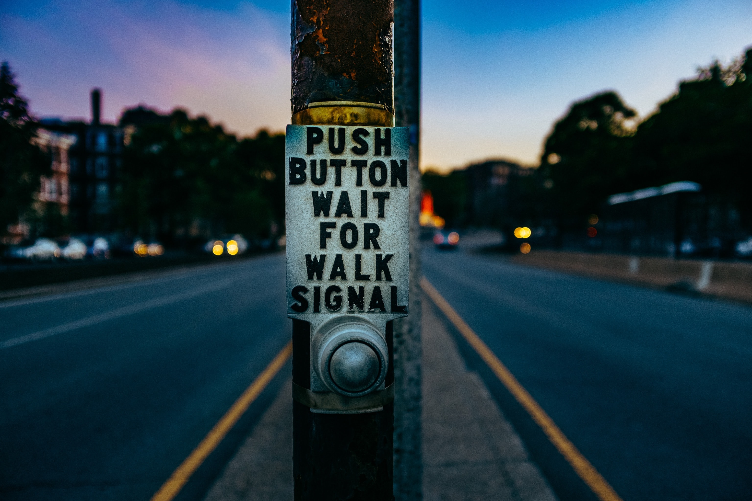 Sign that says push button to wait for walk signal Sign that says push button to wait for walk signal