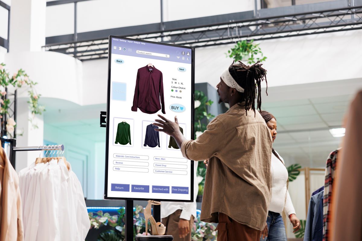 customer browsing clothing options using digital signage kiosk