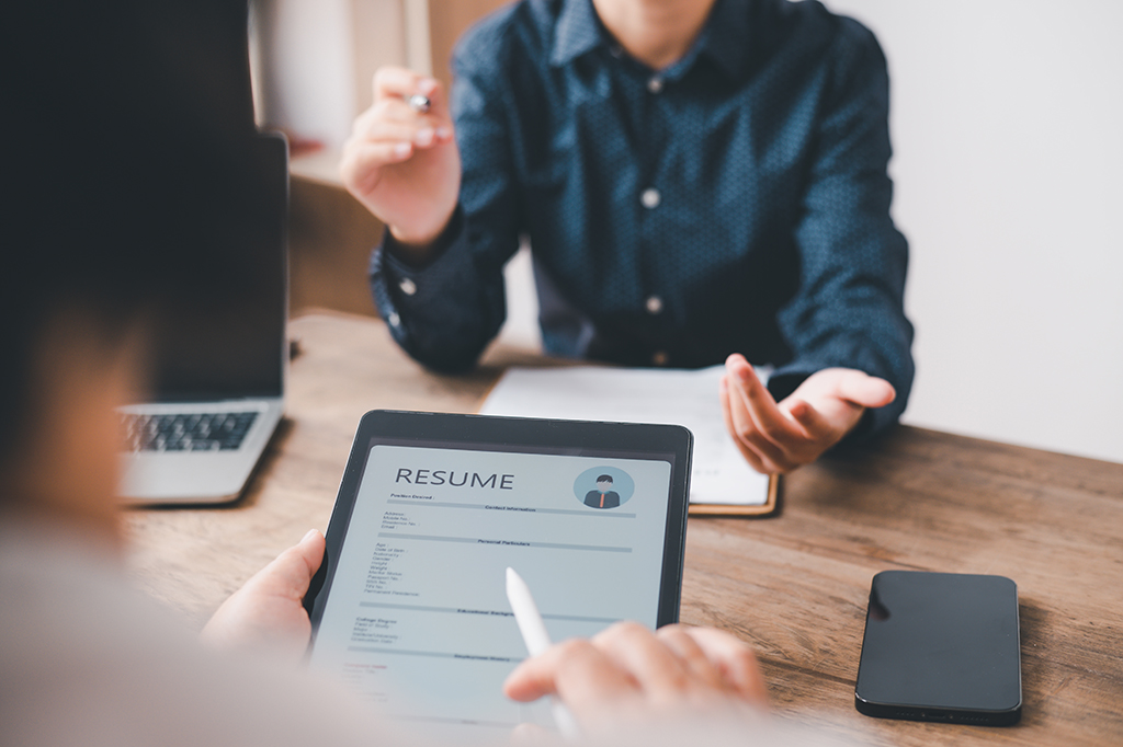 A nonprofit board member manually reviews a resume pre-screened and flagged by AI. A nonprofit board member manually reviews a resume pre-screened and flagged by AI.