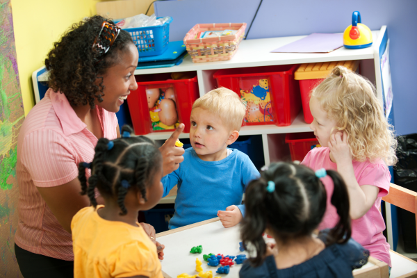 A Preschool La Centerra educator assisting students